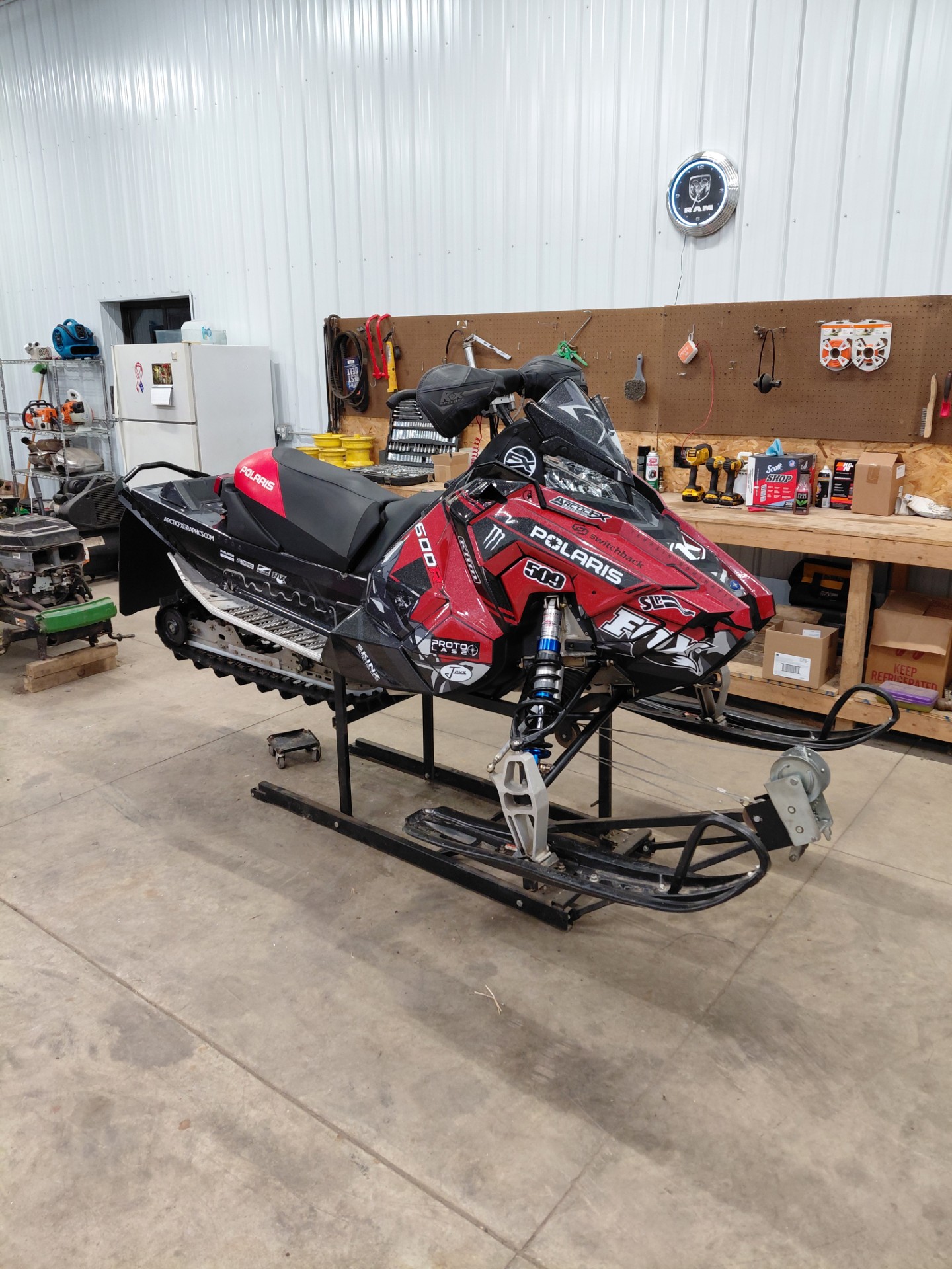 A Polaris Axys 600R snowmobile with a white, black, red, gray Burandt Vista custom wrap with silver flake laminate.