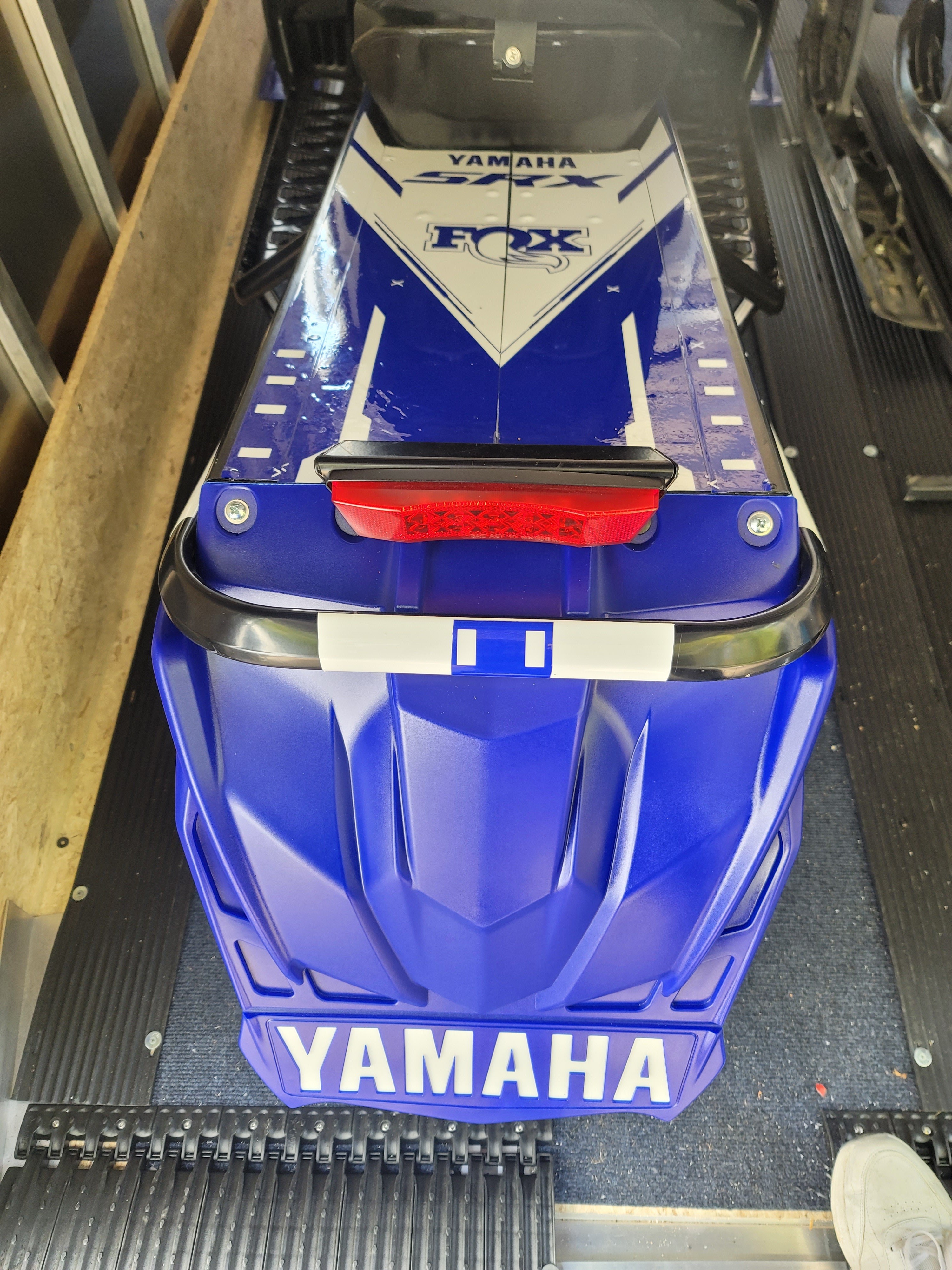 A Yamaha Sidewinder snowmobile with a yamaha blue custom vinyl wrap