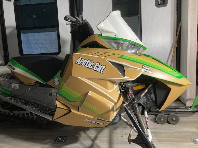 An ArcticCat Proclimb snowmobile with a black, white, light brown, pearl green, electric green, lime green, and hyper green Retro Cat custom vinyl wrap with matte laminate.
