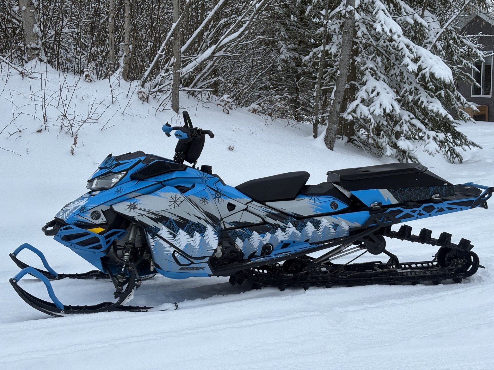 A Ski-Doo Gen4 Narrow Body snowmobile with a charcoal gray, black, octane blue, light gray, scandinavian blue, and white Absolute Zero custom vinyl wrap with matte laminate.