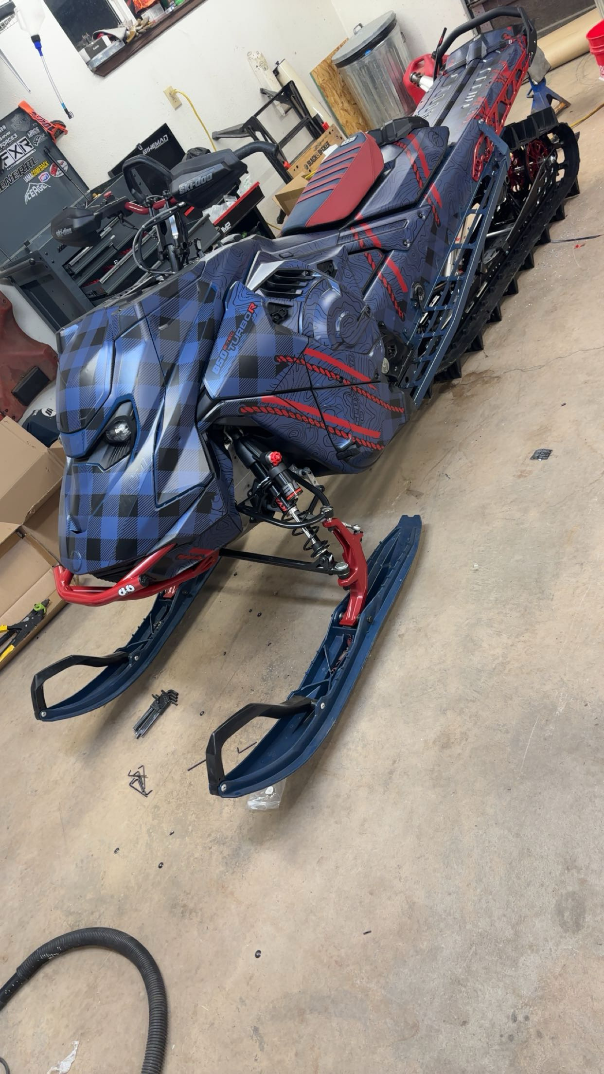 A Ski-Doo Gen5 Mountain snowmobile with a dusty navy, black, and sunset red SledStar Bushmaster custom vinyl wrap with matte laminate.
