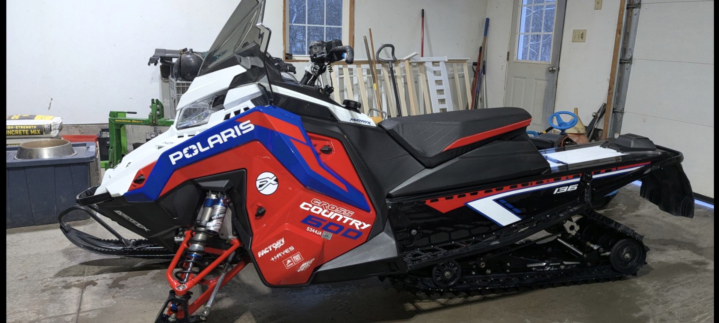 A Polaris Matryx Trail snowmobile with a white, black, Polaris red, and polar blue Lavallee Retro 94 XCR custom vinyl wrap.