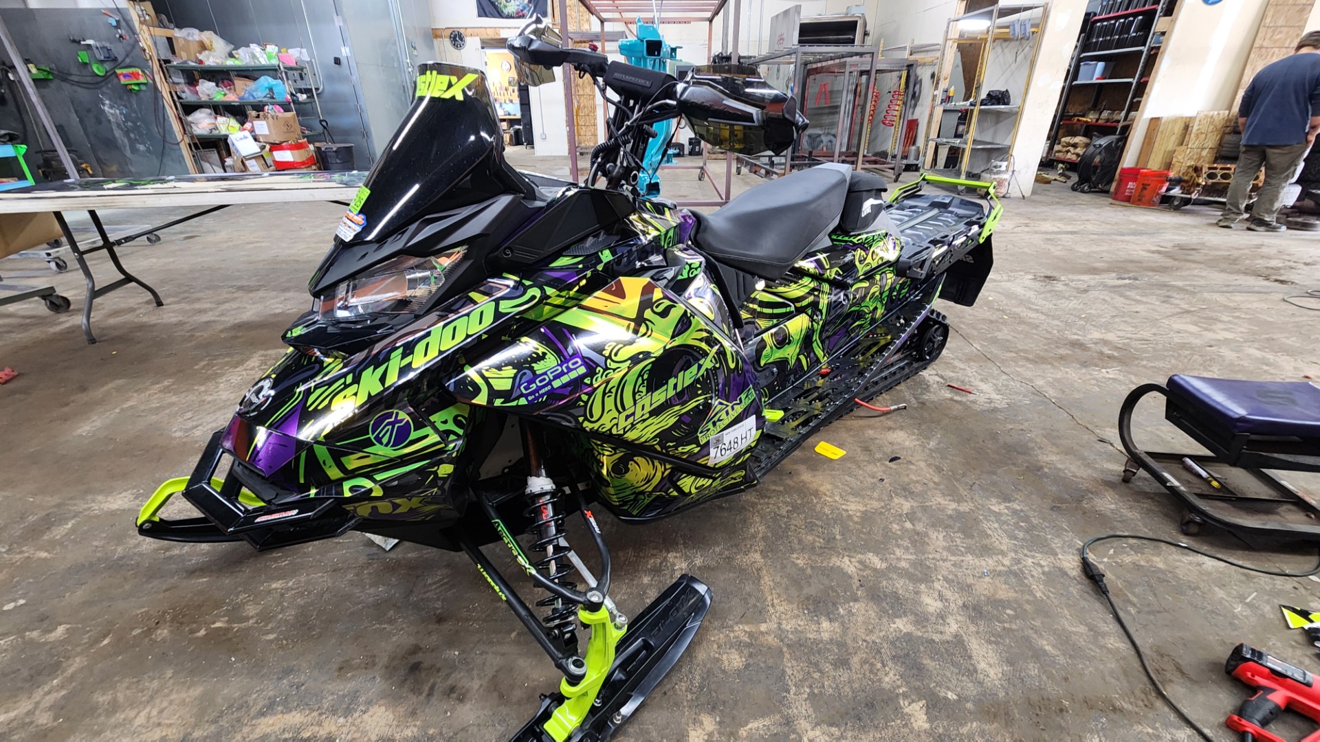 A Ski-Doo Gen4 Narrow Body snowmobile with a khaos purple, manta green, black, helio purple, and stealth gray Onasch Fueled custom vinyl wrap with chrome vinyl.