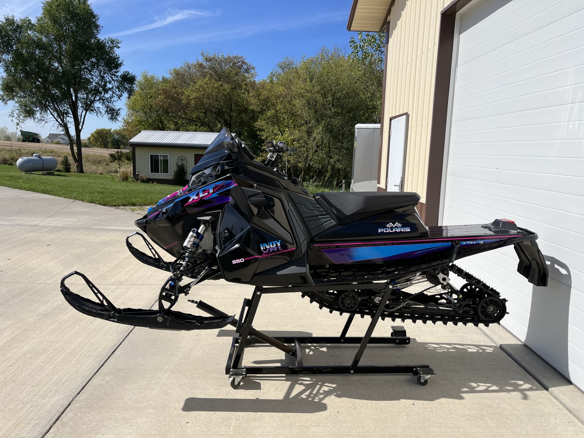 A Polaris Matryx Trail snowmobile with a black, hot pink, khaos purple, and sky blue Retro XLT custom vinyl wrap.