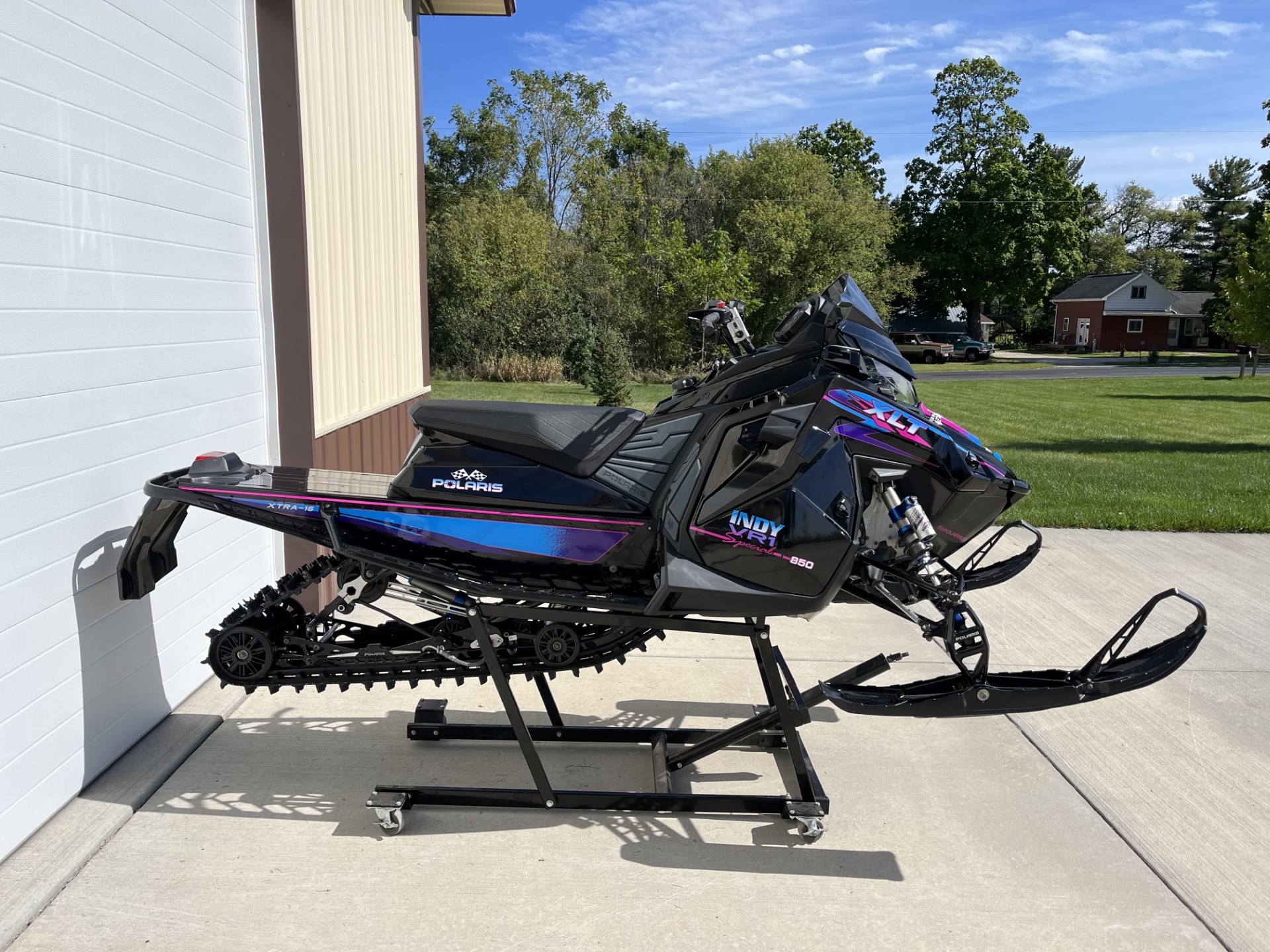 A Polaris Mataryx Trail snowmobile with a black, hot pink, khaos purple, and sky blue Retro XLT custom vinyl wrap.