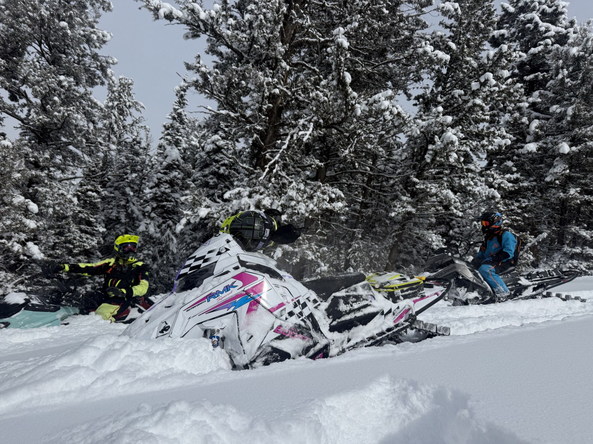 A Polaris Matryx Mountain snowmobile with a black, white, hot pink, violet purple, lilac purple, and octane blue Retro 96 XLT custom vinyl wrap.