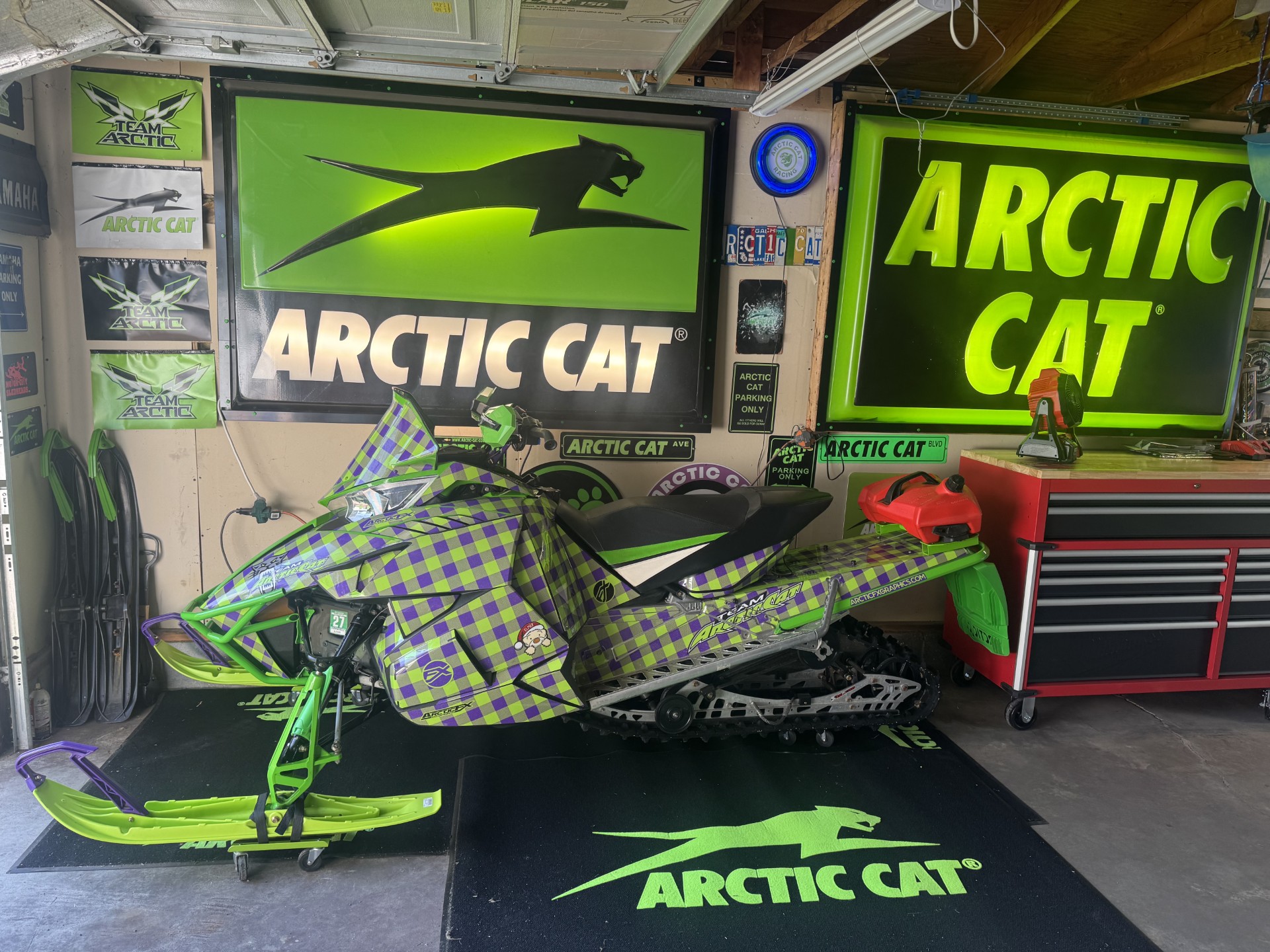 An ArcticCat Procross snowmobile with a lime green and purple custom plaid custom vinyl wrap with halo flake laminate.