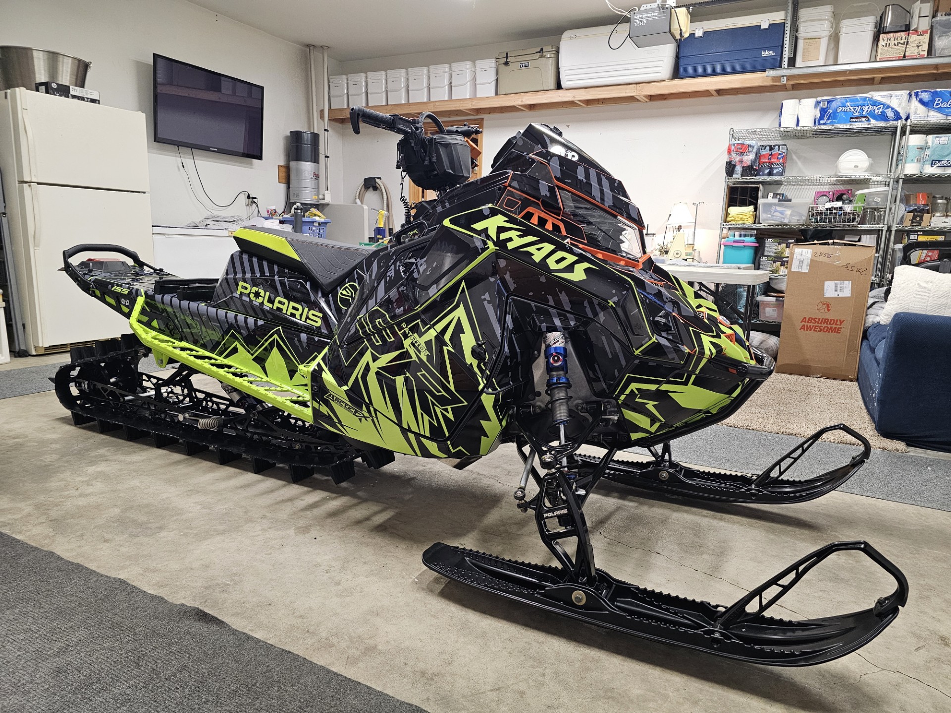 A Polaris Matryx Mountain snowmobile with a black, asphalt gray, and manta green Altitude custom vinyl wrap.