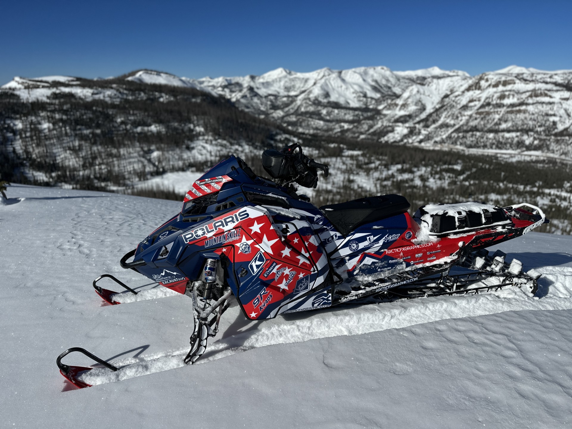 A Polaris Matryx Mountain snowmobile with a navy blue, Polaris red, and white Leif Alvarasson Merica custom vinyl wrap with matte laminate.