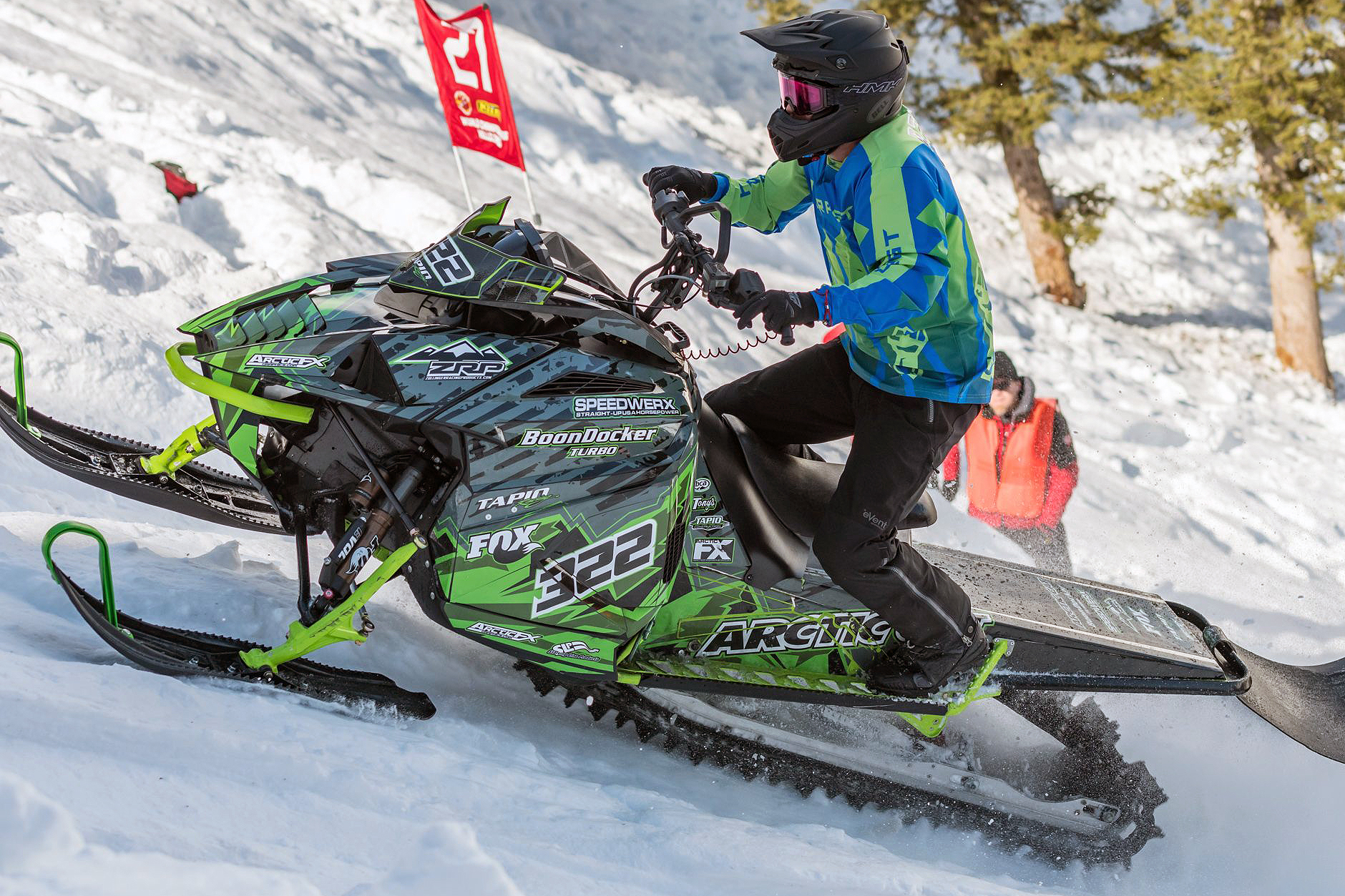 A Arctic Cat Ascender snowmobile with a green, gray, and black mountain Altitude custom vinyl wrap.
