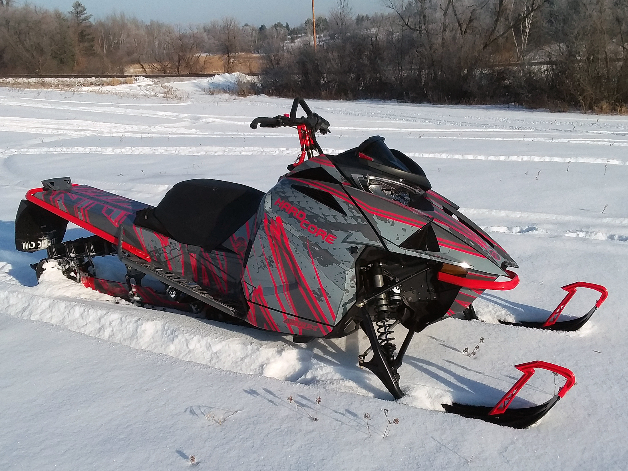 A Arctic Cat Ascender snowmobile with a red and gray grunge stripes DangerZone custom vinyl wrap.