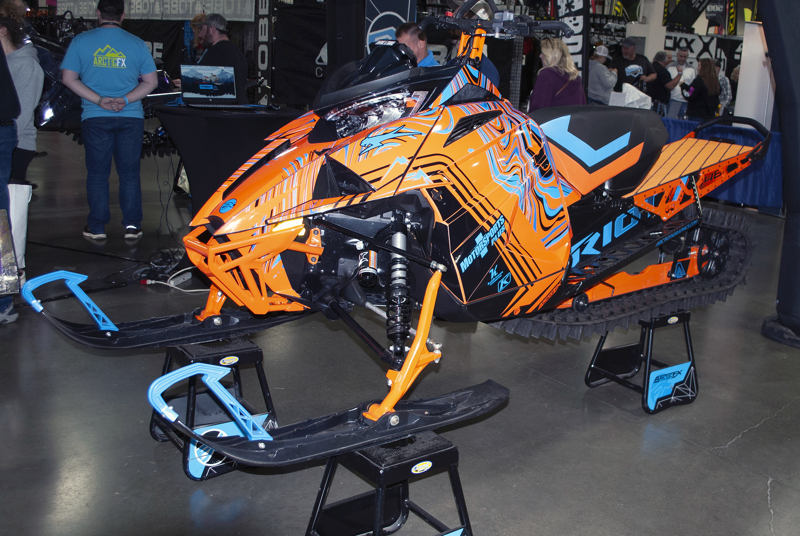 A Arctic Cat Ascender snowmobile with a orange and blue DF36 Psych custom vinyl wrap.