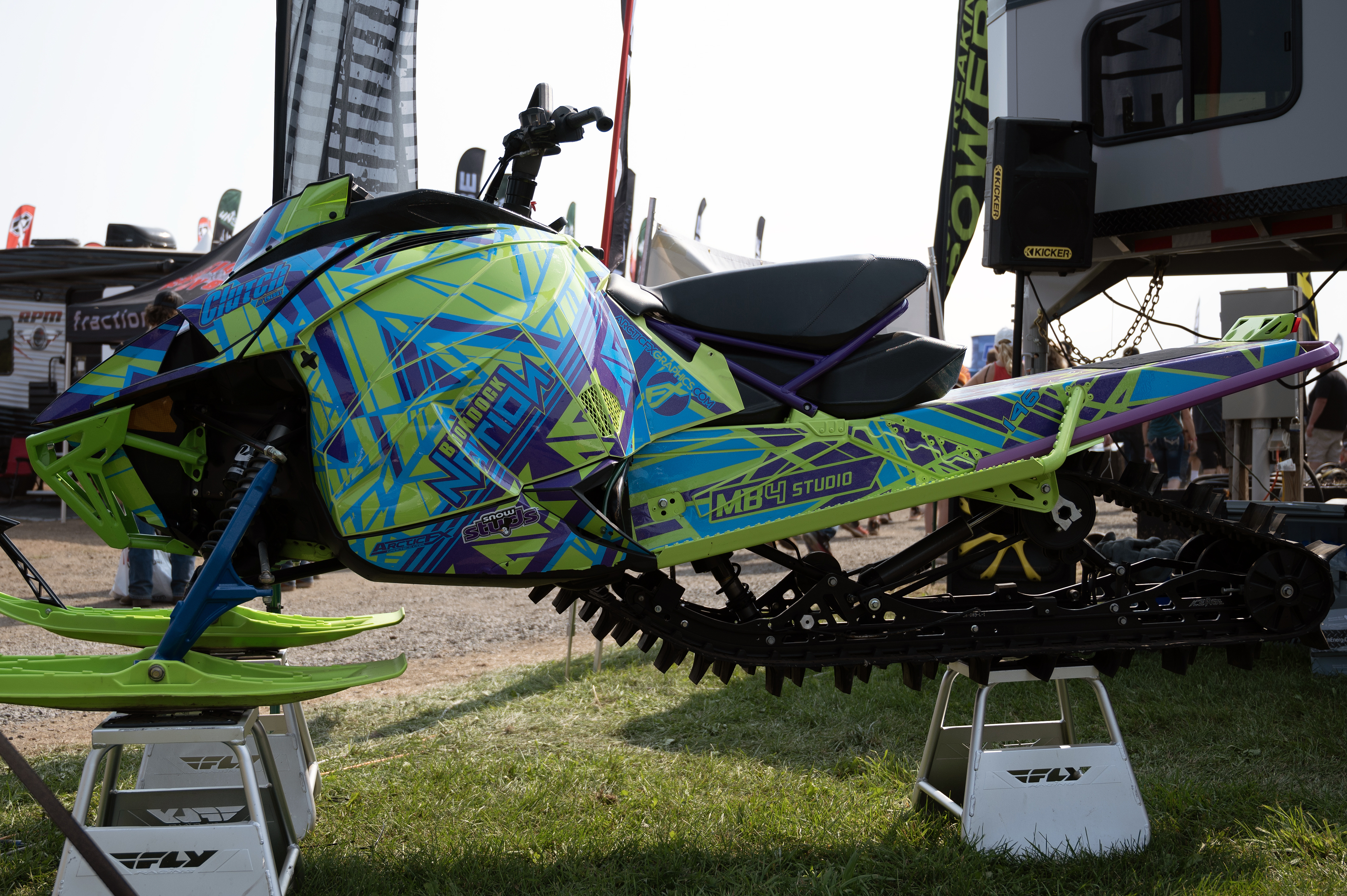 A Arctic Cat Next-Gen snowmobile with a blue, purple, and green MB4 Mayhem custom vinyl wrap.