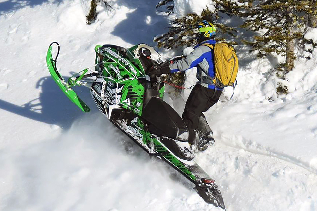 A Arctic Cat Proclimb snowmobile with a white, green, and black grunge mountain Altitude custom vinyl wrap.