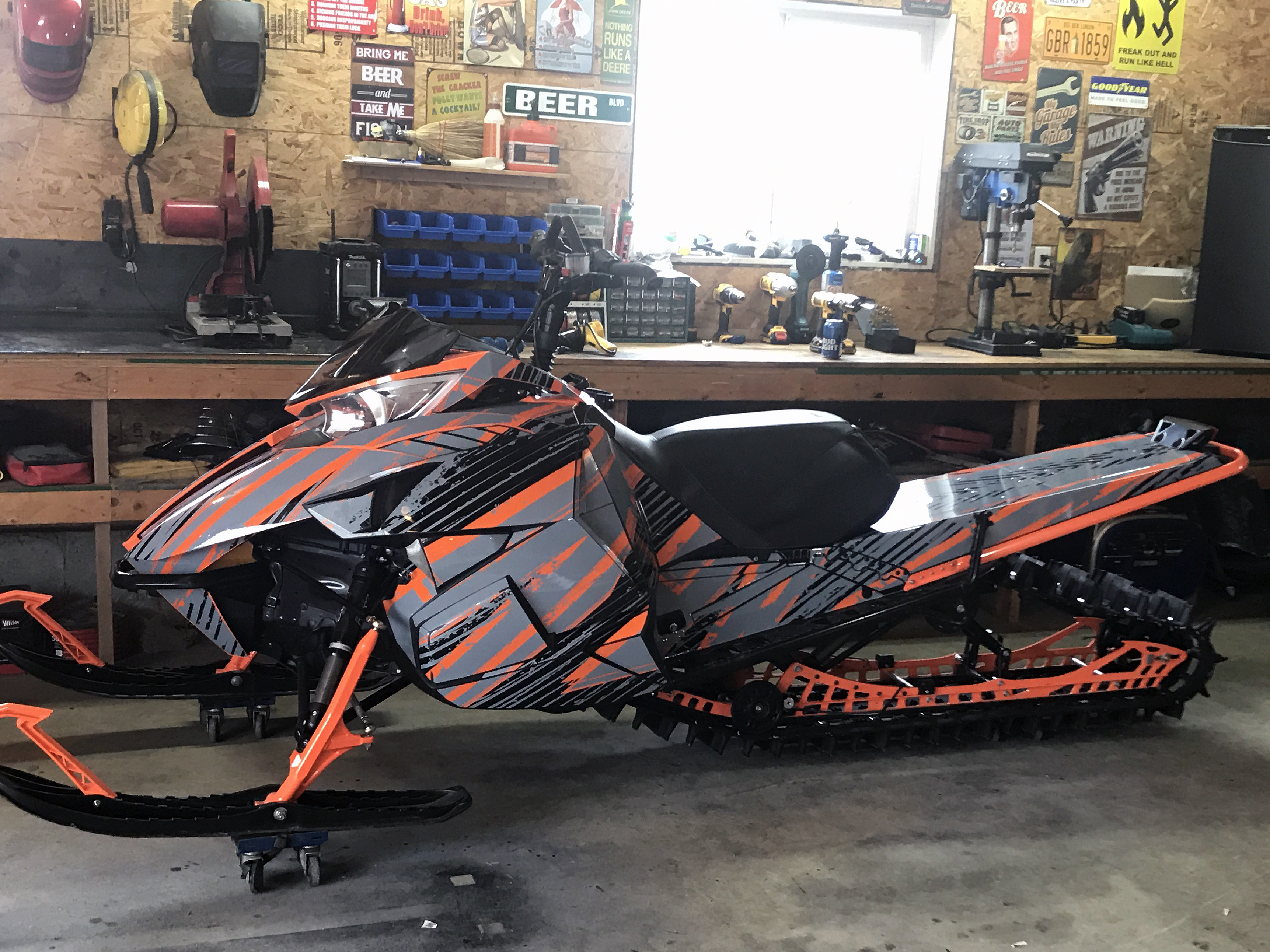 A Arctic Cat Proclimb snowmobile with a orange, gray and black grunge stripes Blackout custom vinyl wrap.