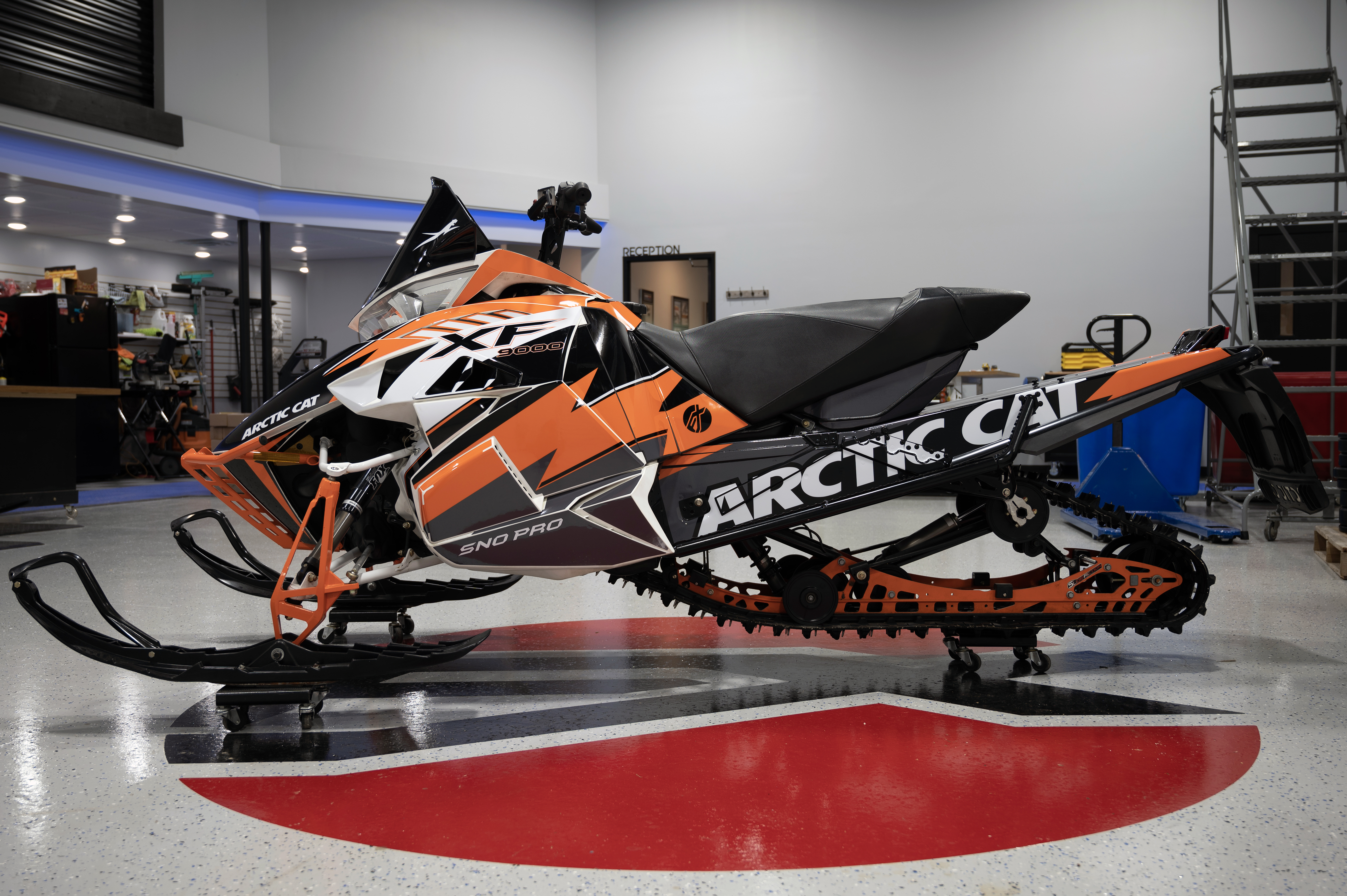 A Arctic Cat Procross snowmobile with a orange, white and black lightning Bolt custom vinyl wrap.
