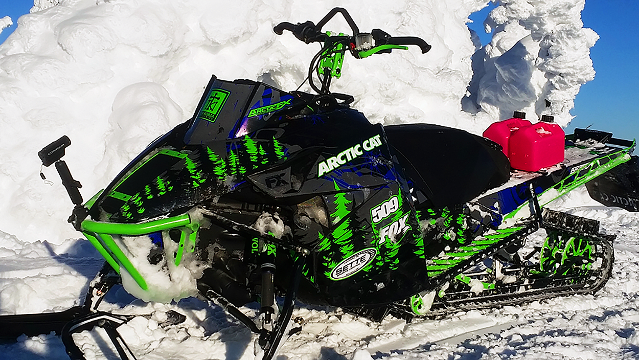 A Arctic Cat Procross snowmobile with a blue, green, and black trees Sub Zero custom vinyl wrap.