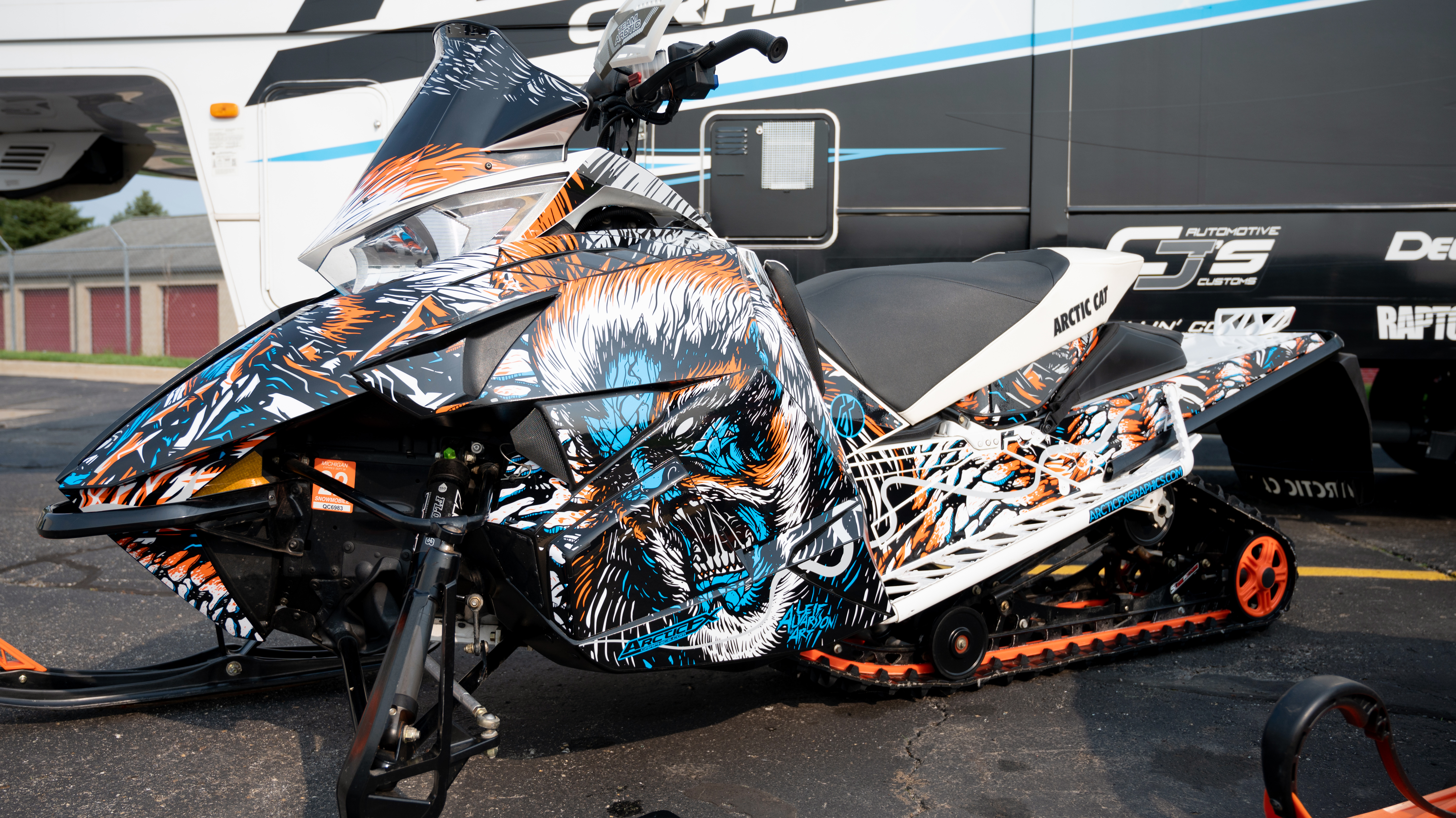 A Arctic Cat Procross snowmobile with a orange, blue, and black yeti Leif Alvarsson Tree Slayer custom vinyl wrap.