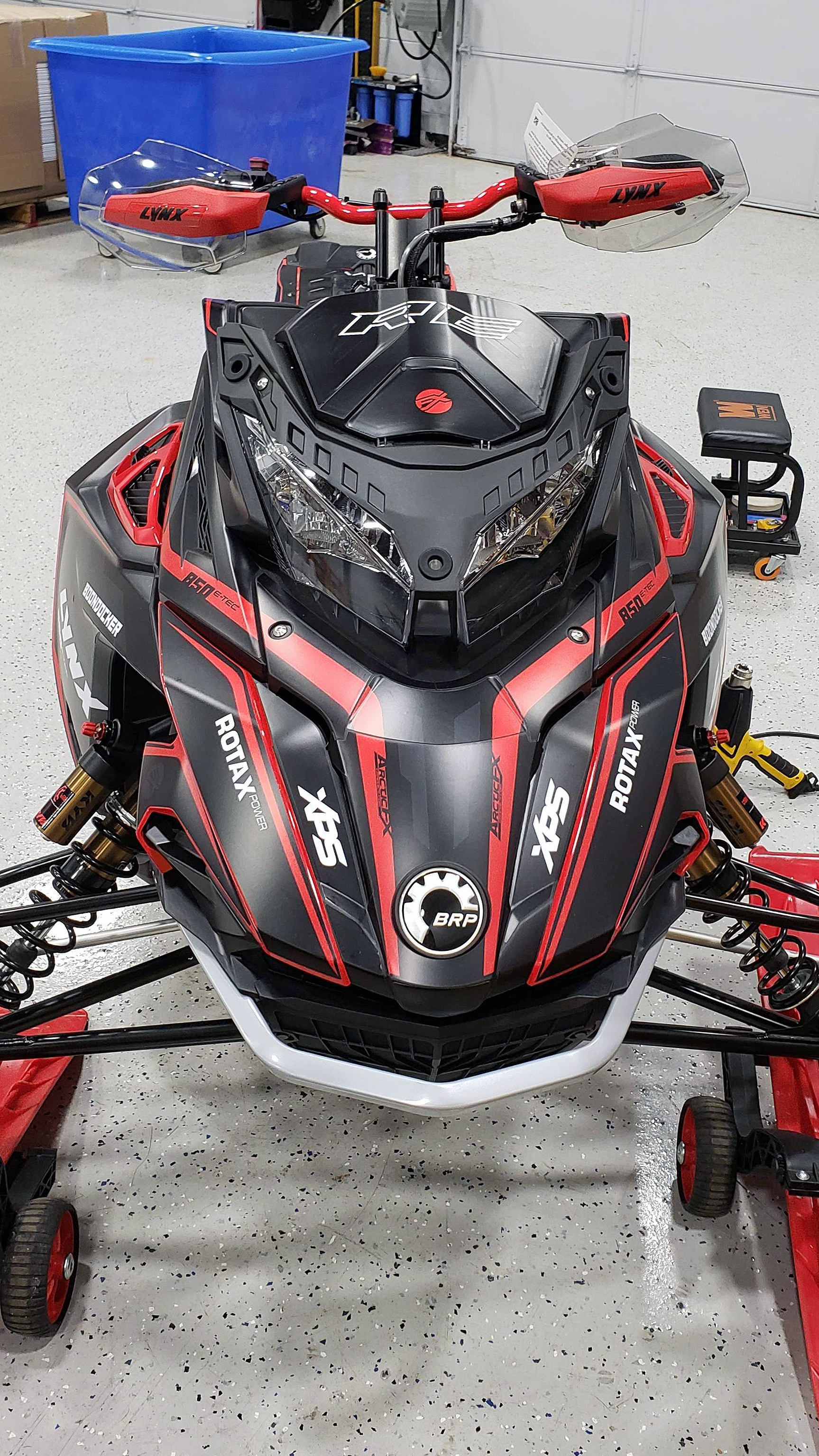 A Lynx snowmobile with a black solid color custom vinyl wrap with stock logos added.
