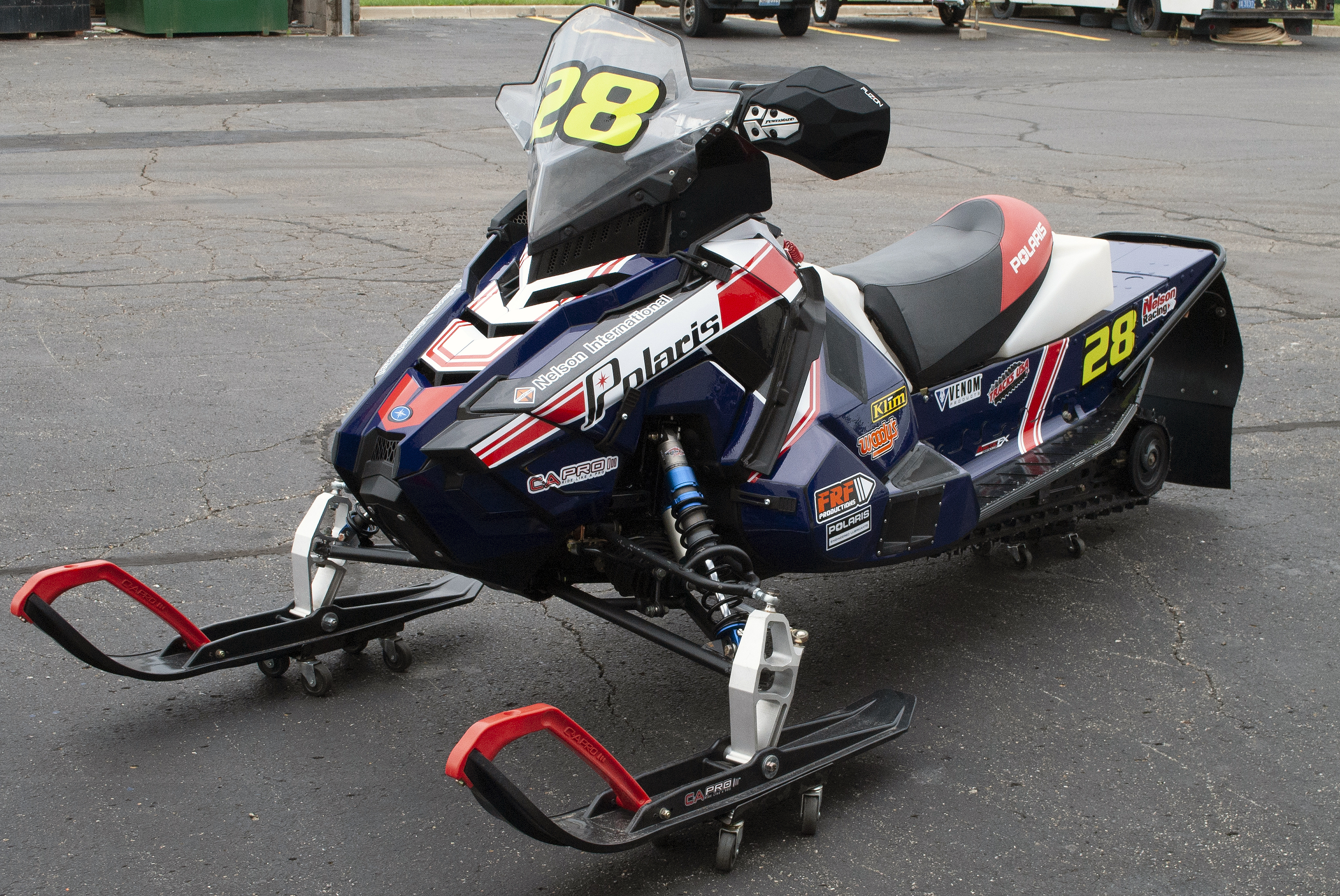 A Polaris Axys 600r snowmobile with a red, white, and blue retro Nelson racing custom vinyl wrap.