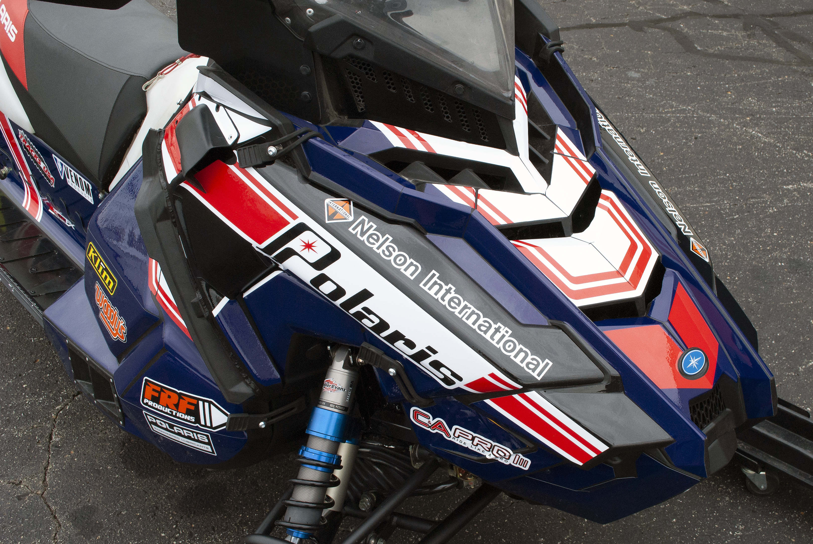 A Polaris Axys 600r snowmobile with a red, white, and blue retro Nelson racing custom vinyl wrap.