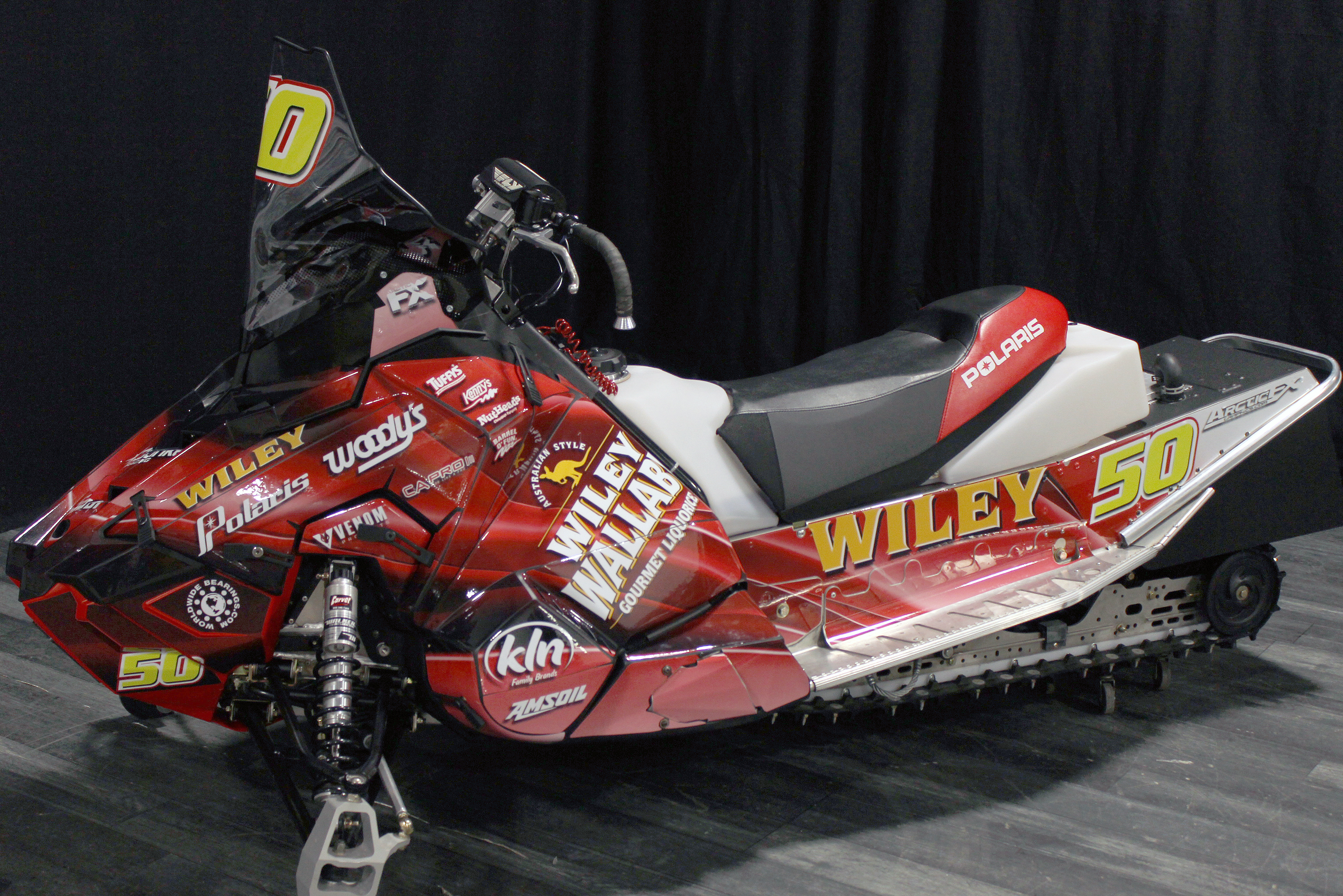 A Polaris Axys 600r snowmobile with a red licorice Wiley Wallaby racing custom vinyl wrap.