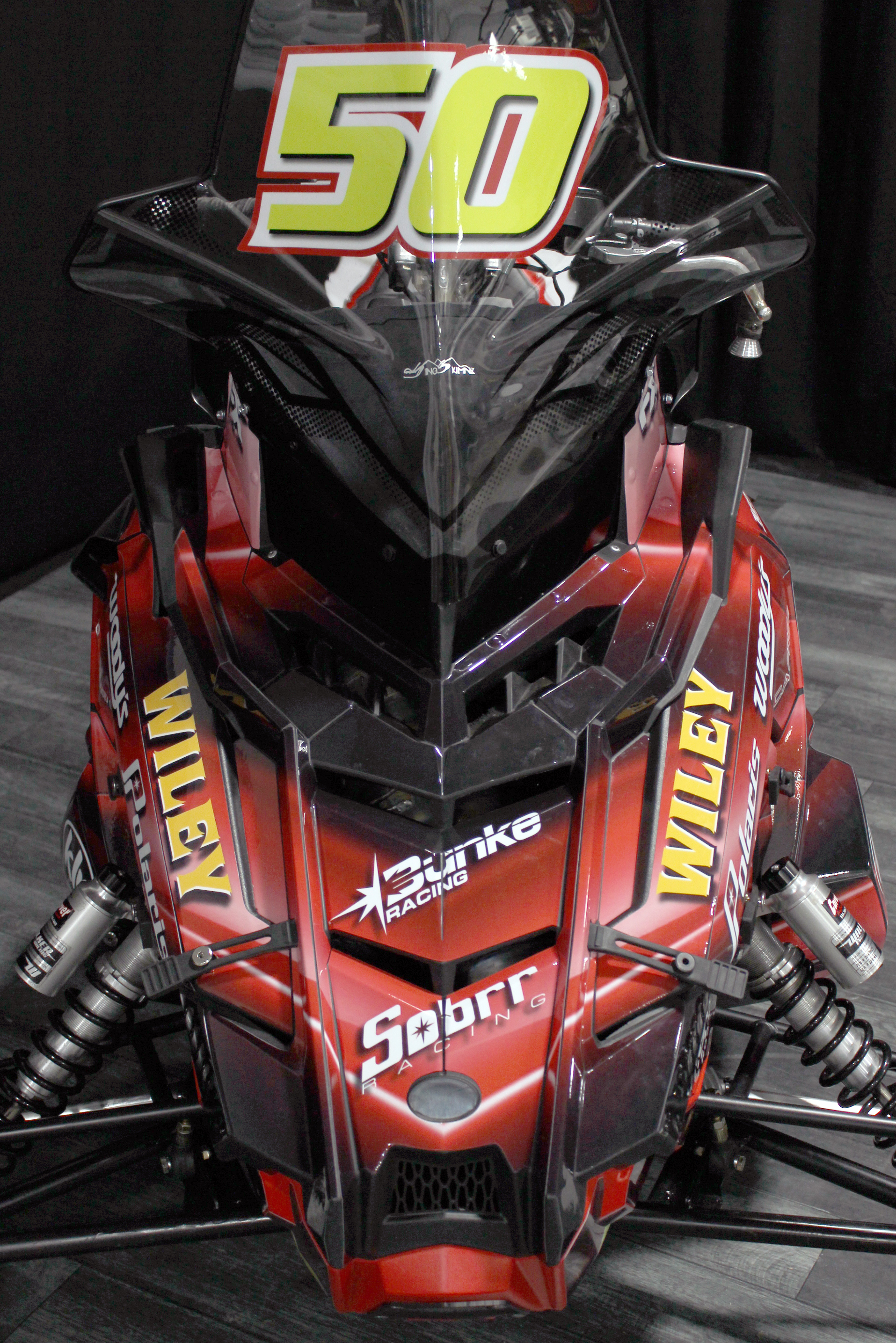 A Polaris Axys 600r snowmobile with a red licorice Wiley Wallaby racing custom vinyl wrap.