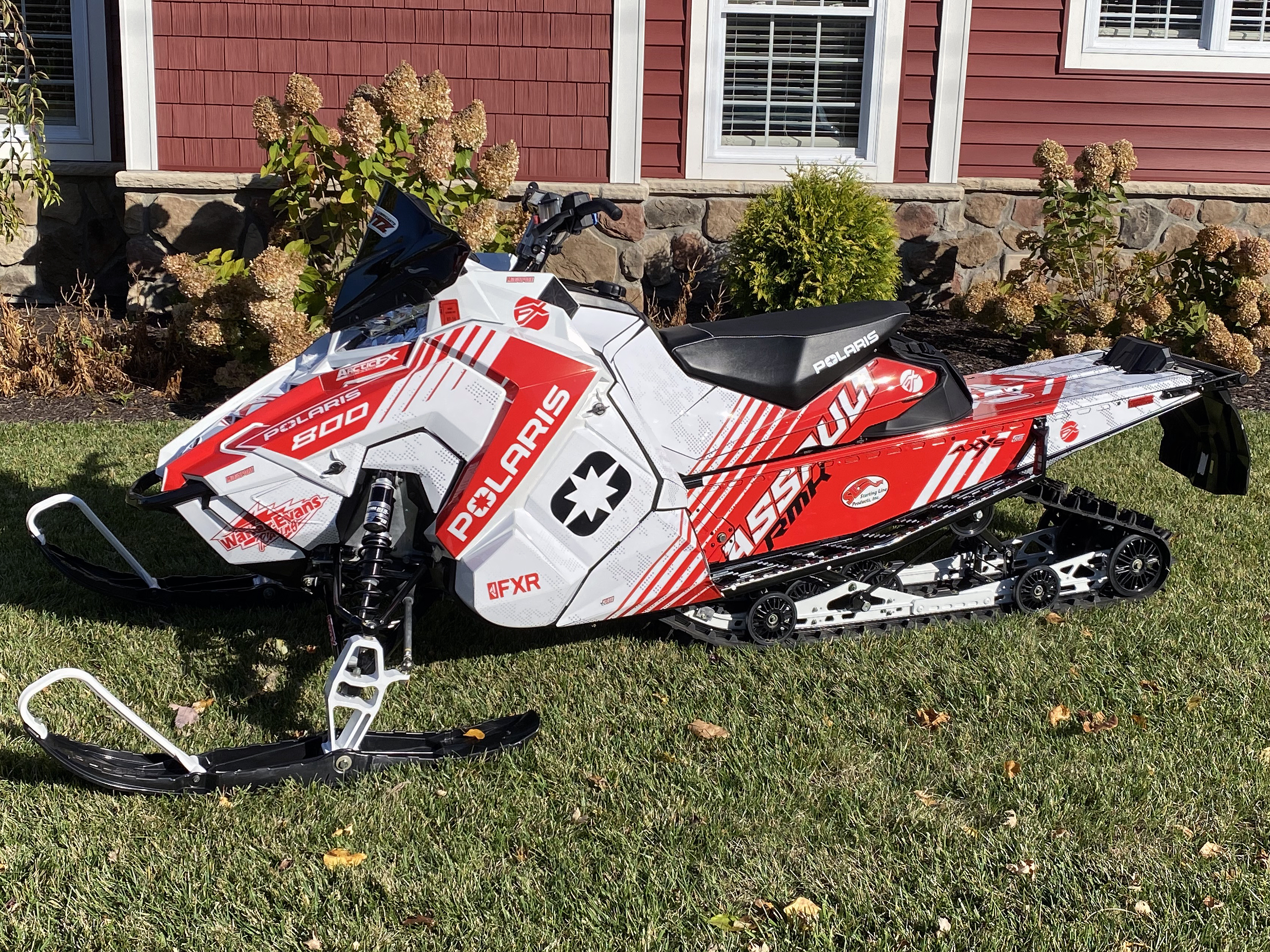 A Polaris Axys Crossover snowmobile with a white, black, and red stripes Armada custom vinyl wrap.