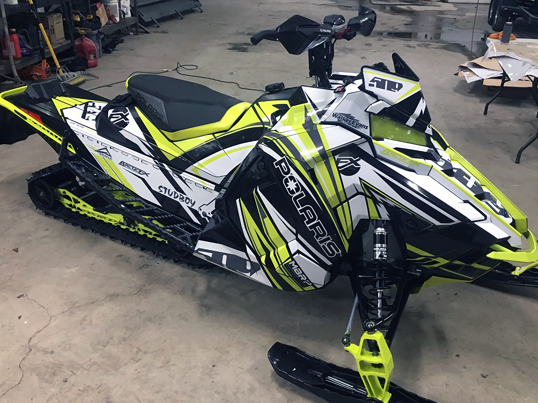 A Polaris Axys Crossover snowmobile with a lime squeeze, white, and black stripes Kesterke Adrenaline custom vinyl wrap.