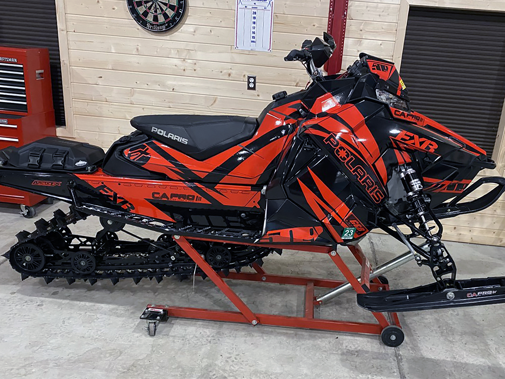 A Polaris Axys Crossover snowmobile with a red and black Kesterke Adrenaline custom vinyl wrap.