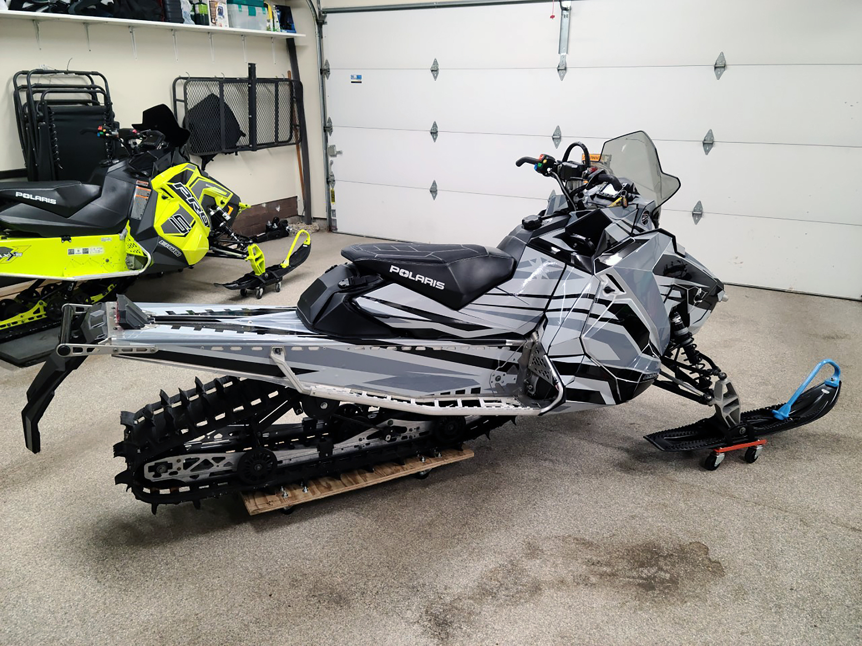 A Polaris Axys Crossover snowmobile with a black and gray Relay custom vinyl wrap.