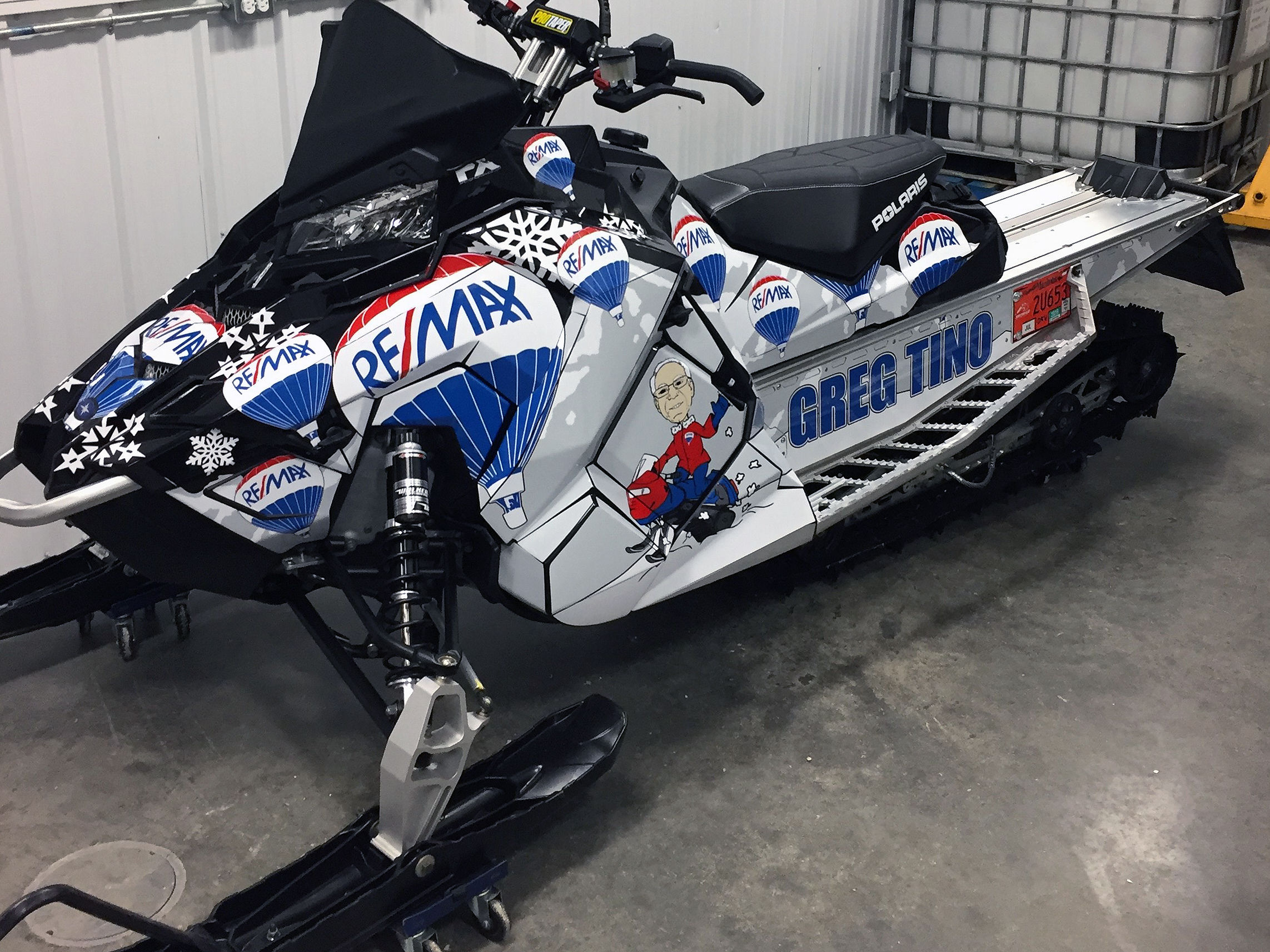 A Polaris Axys Crossover snowmobile with a red, white, and blue balloons Remax custom vinyl wrap.
