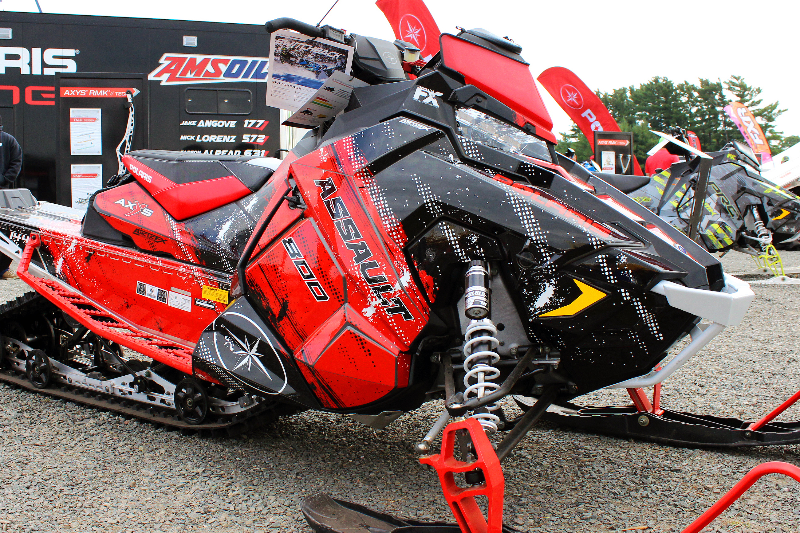 A Polaris Axys Crossover snowmobile with a red. white, and black grunge Sabotage custom vinyl wrap.