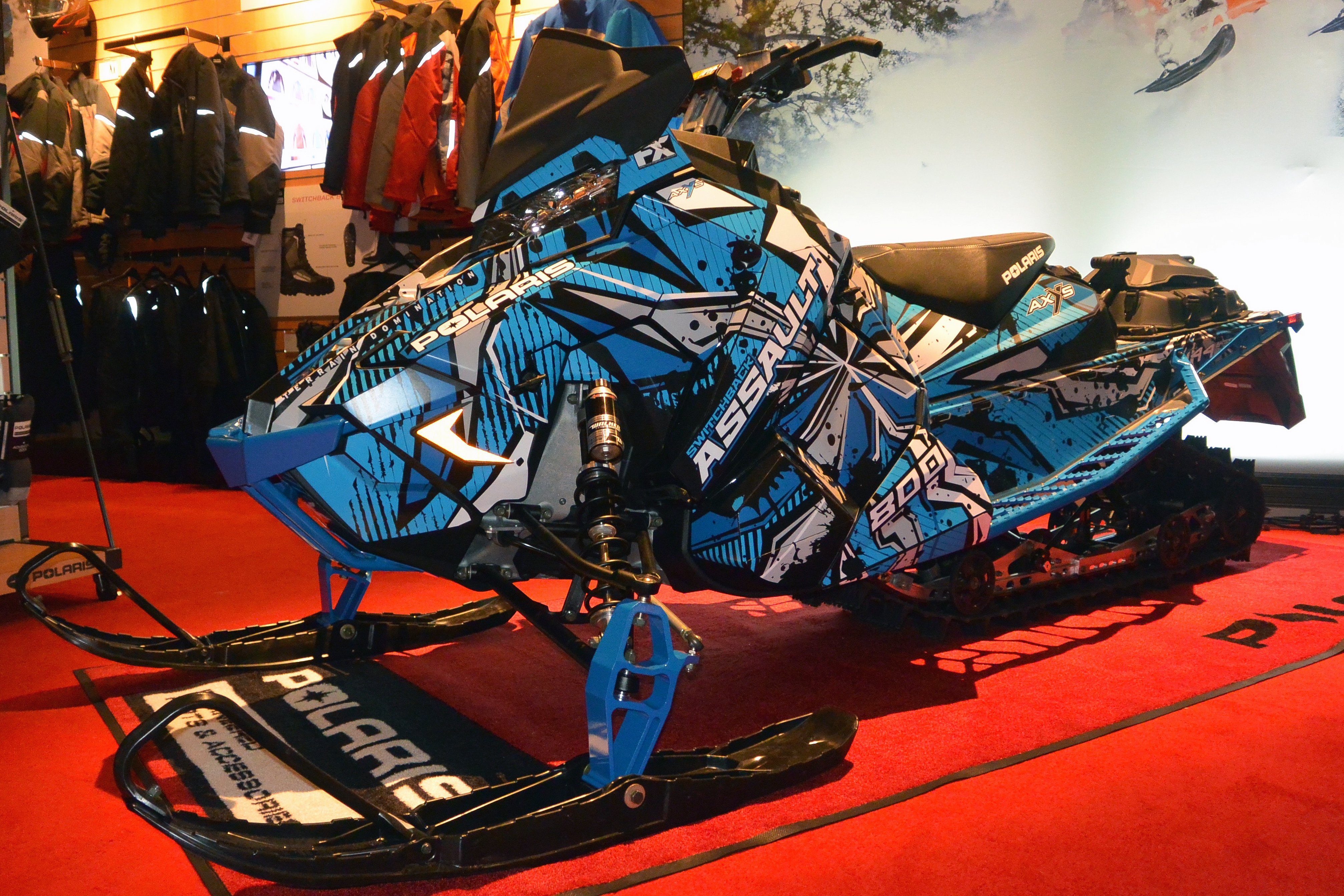 A Polaris Axys Crossover snowmobile with a white, black, and blue Stricken custom vinyl wrap.