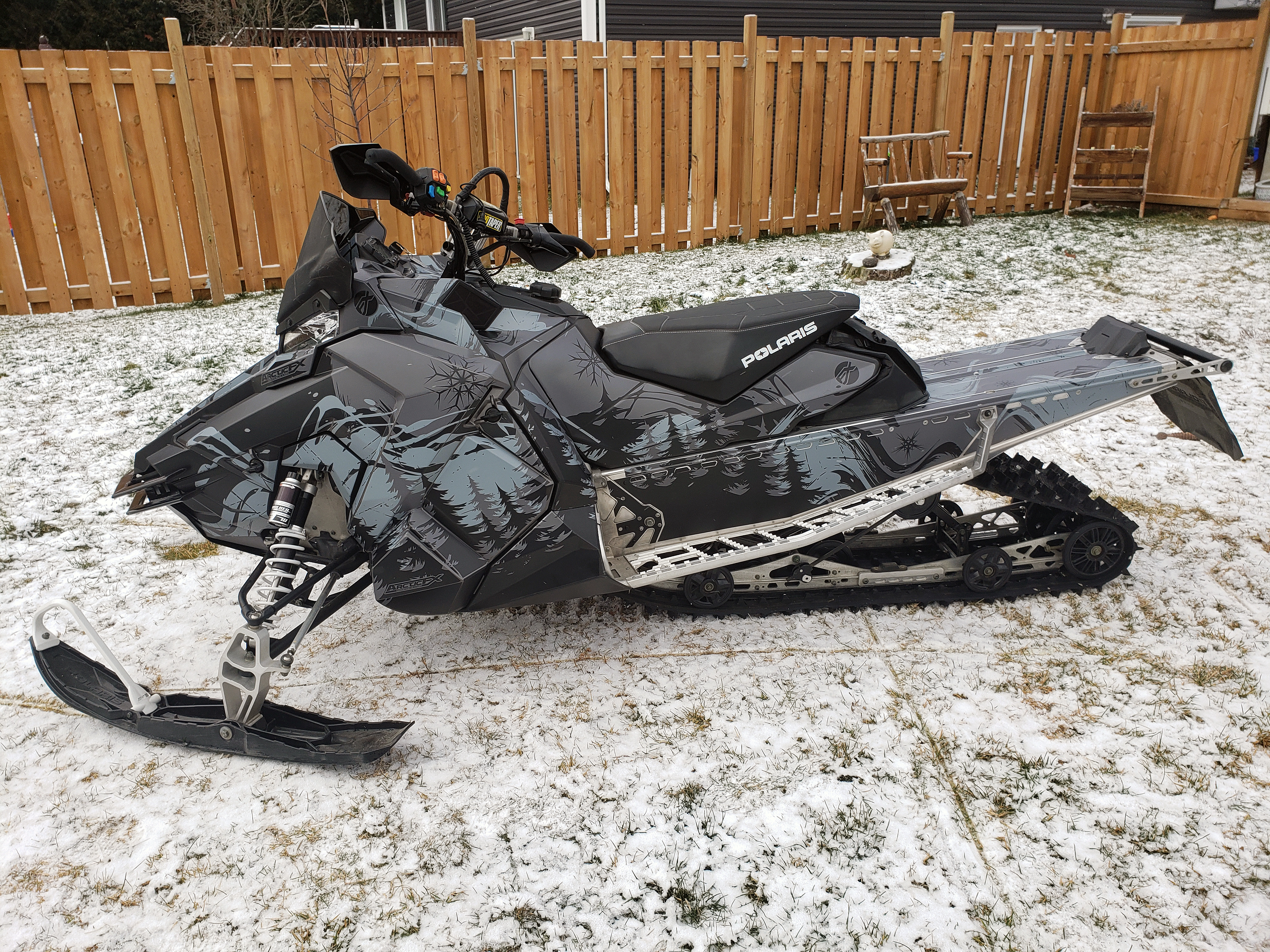 A Polaris Axys Crossover snowmobile with a black and gray Sub Zero custom vinyl wrap.