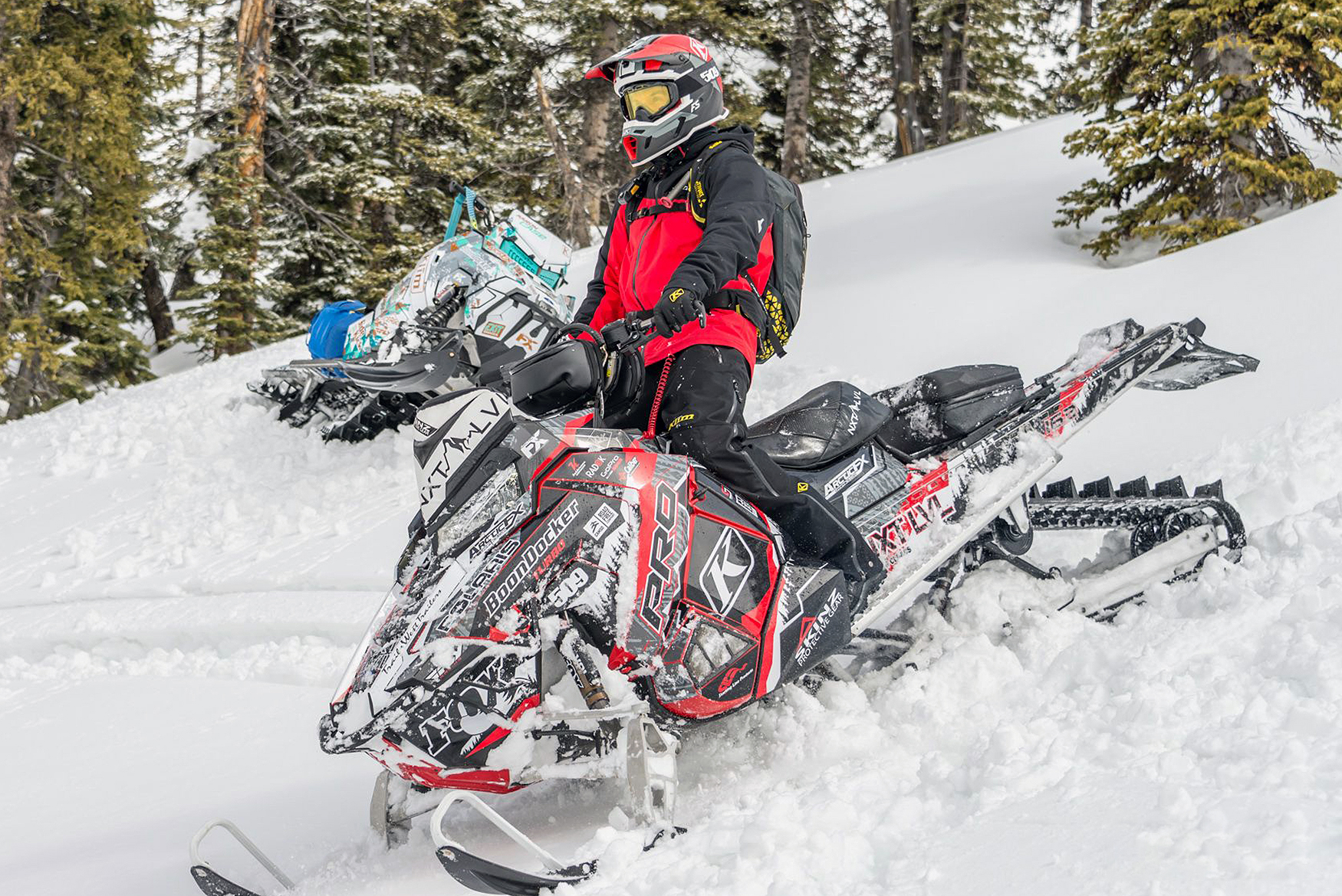 A Polaris Axys Mountain snowmobile with a red, white, and black tribal Adams Alpine custom vinyl wrap.