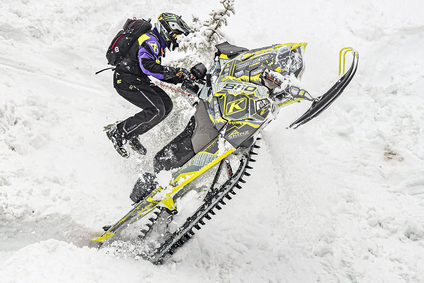 A Polaris Axys Mountain snowmobile with a lime squeeze and black tribal Adams Alpine custom vinyl wrap.