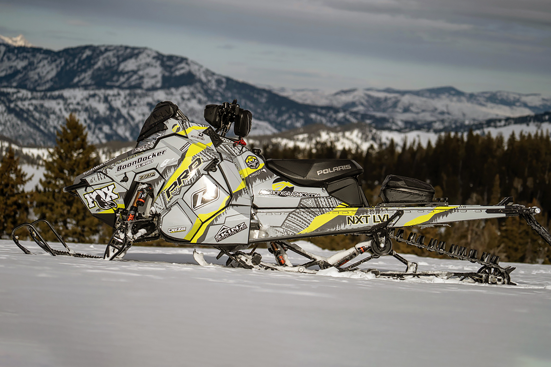 A Polaris Axys Mountain snowmobile with a lime squeeze and gray tribal Adams Alpine custom vinyl wrap.