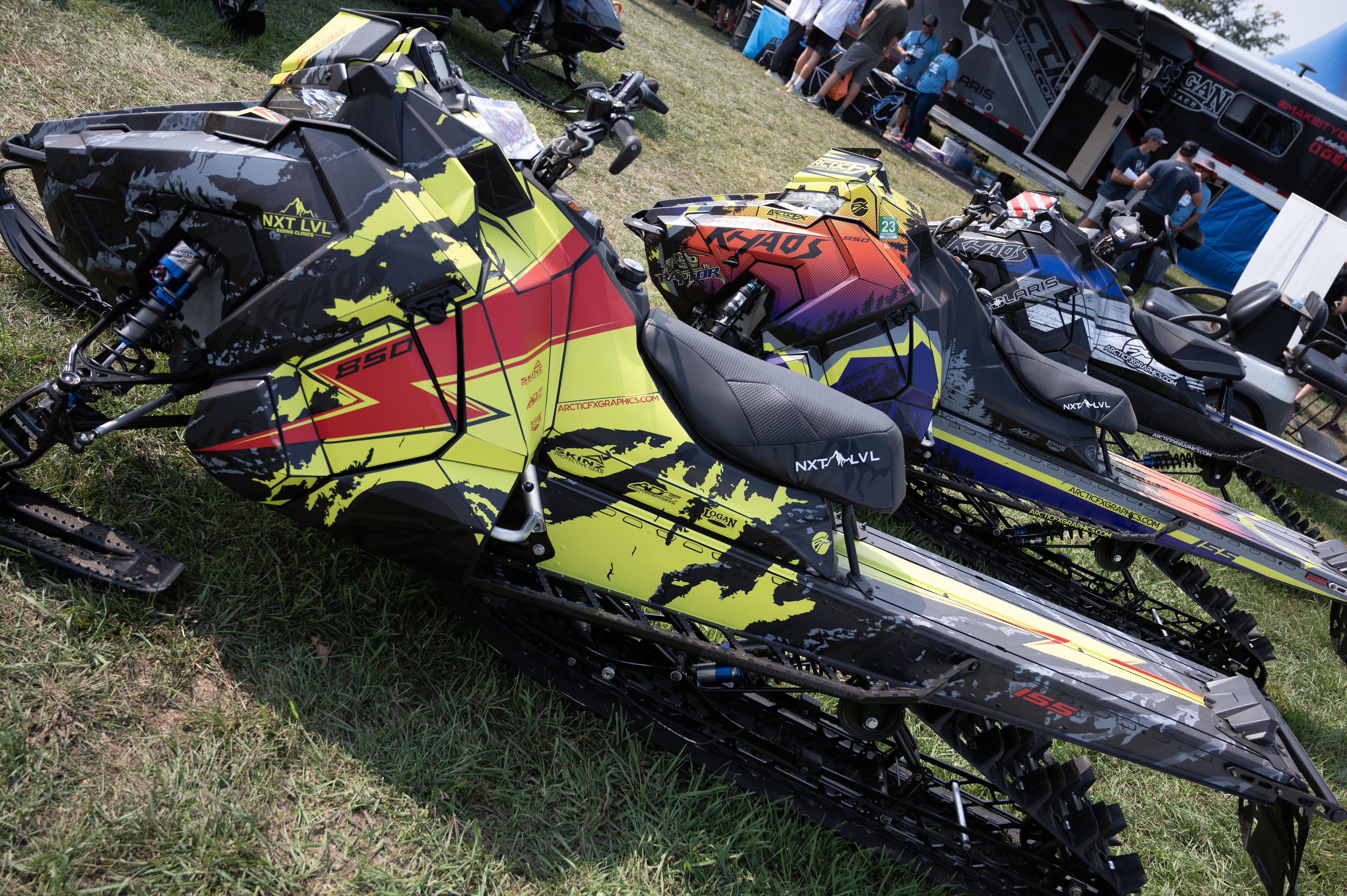 A Polaris Axys Mountain snowmobile with a red, lime squeeze, and black grunge bolt Adams Inversion custom vinyl wrap.