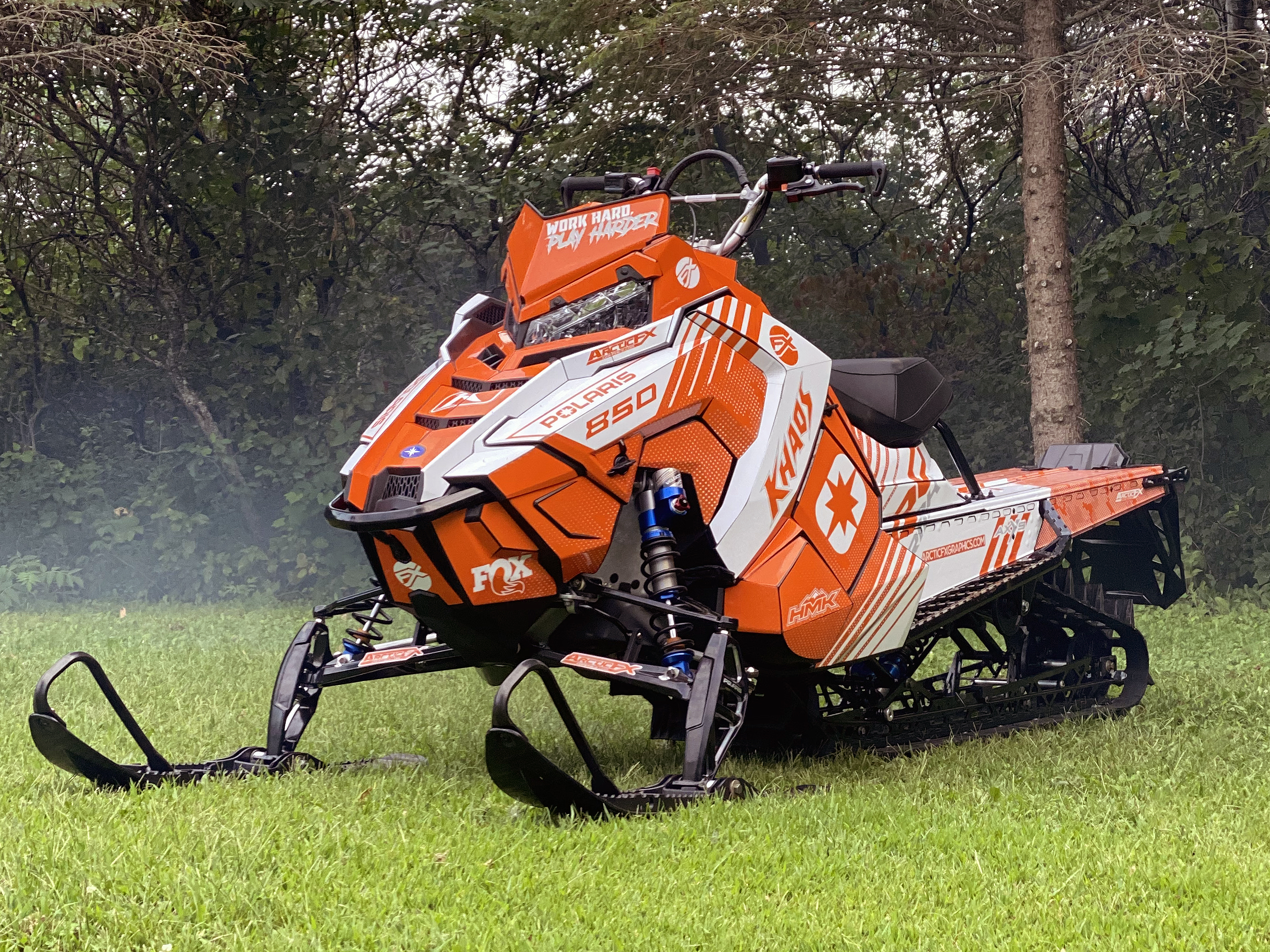 A Polaris Axys Mountain snowmobile with a orange and white Armada custom vinyl wrap.