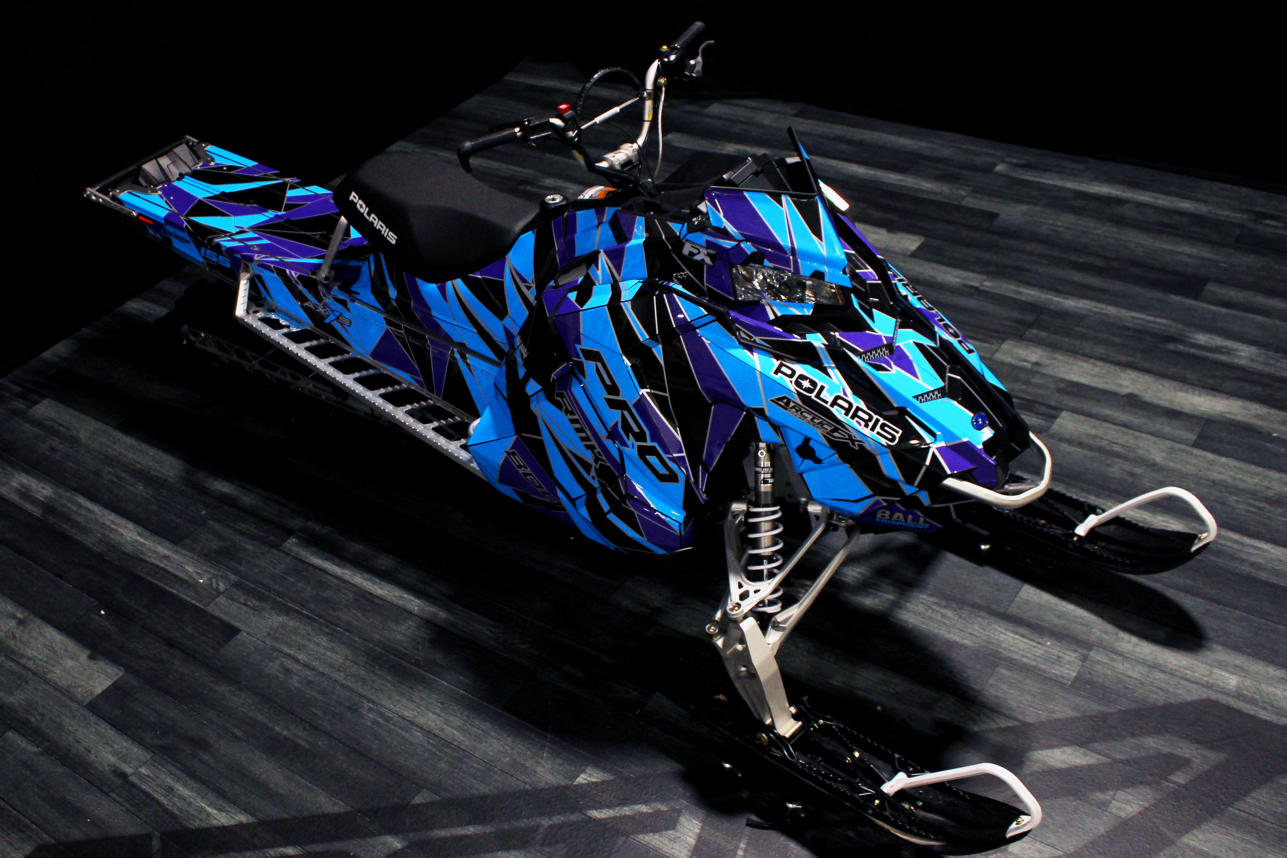 A Polaris Axys Mountain snowmobile with a purple, black, and blue grunge Ascension custom vinyl wrap.