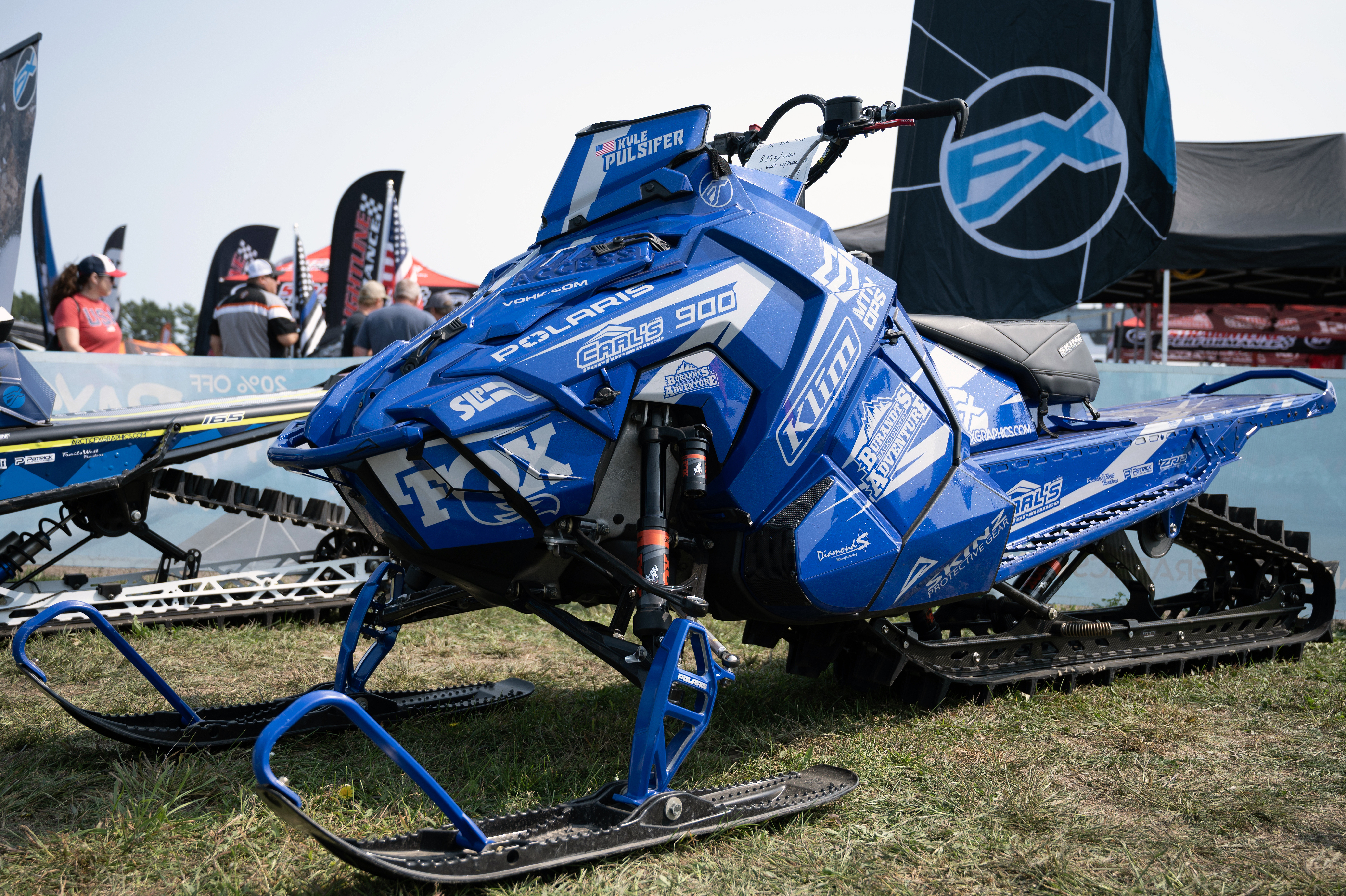 A Polaris Axys Mountain snowmobile with a gray and blue stripes Burandt Evolution custom vinyl wrap.