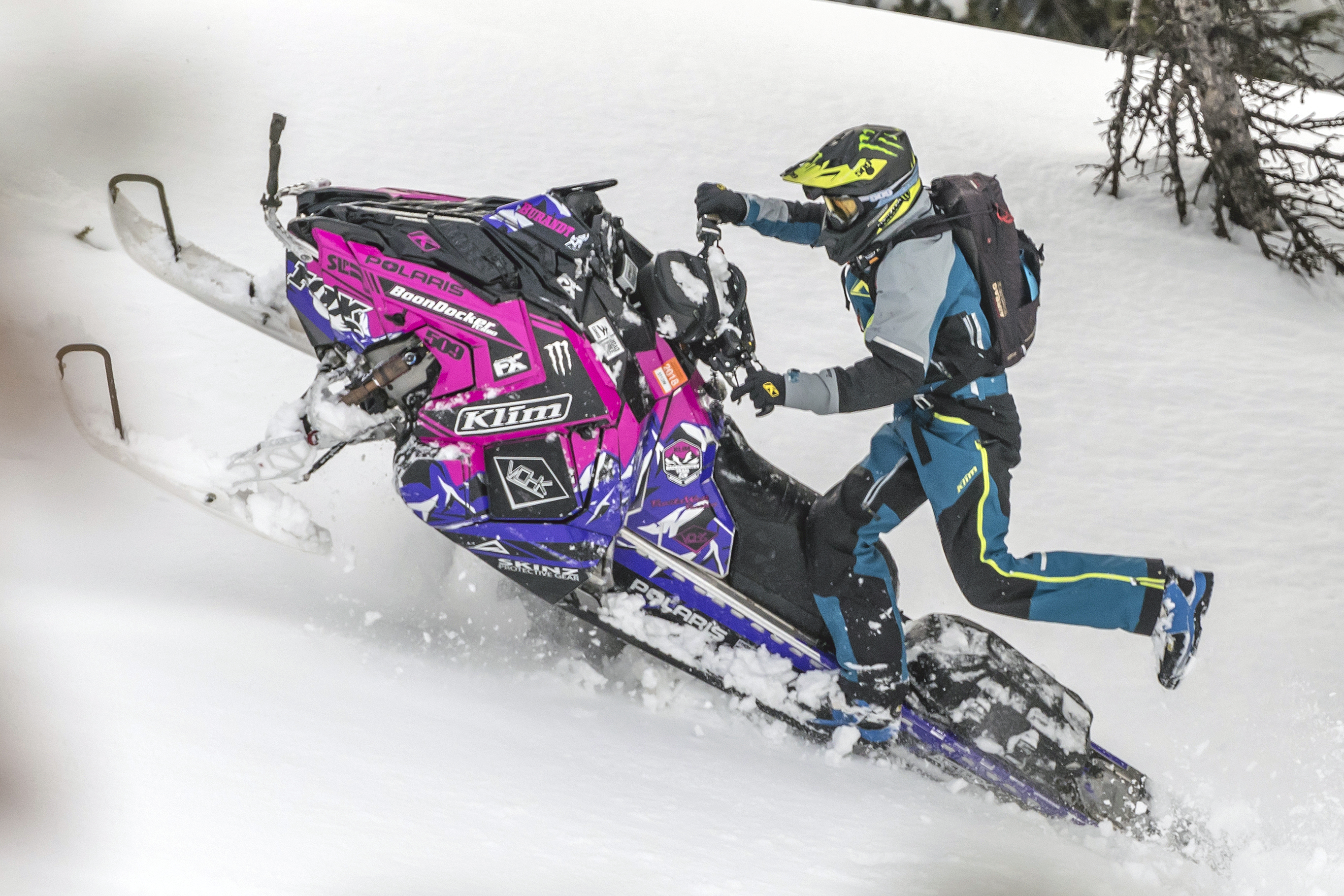 A Polaris Axys Mountain snowmobile with a pink, black, and white Burandt Vista custom vinyl wrap.