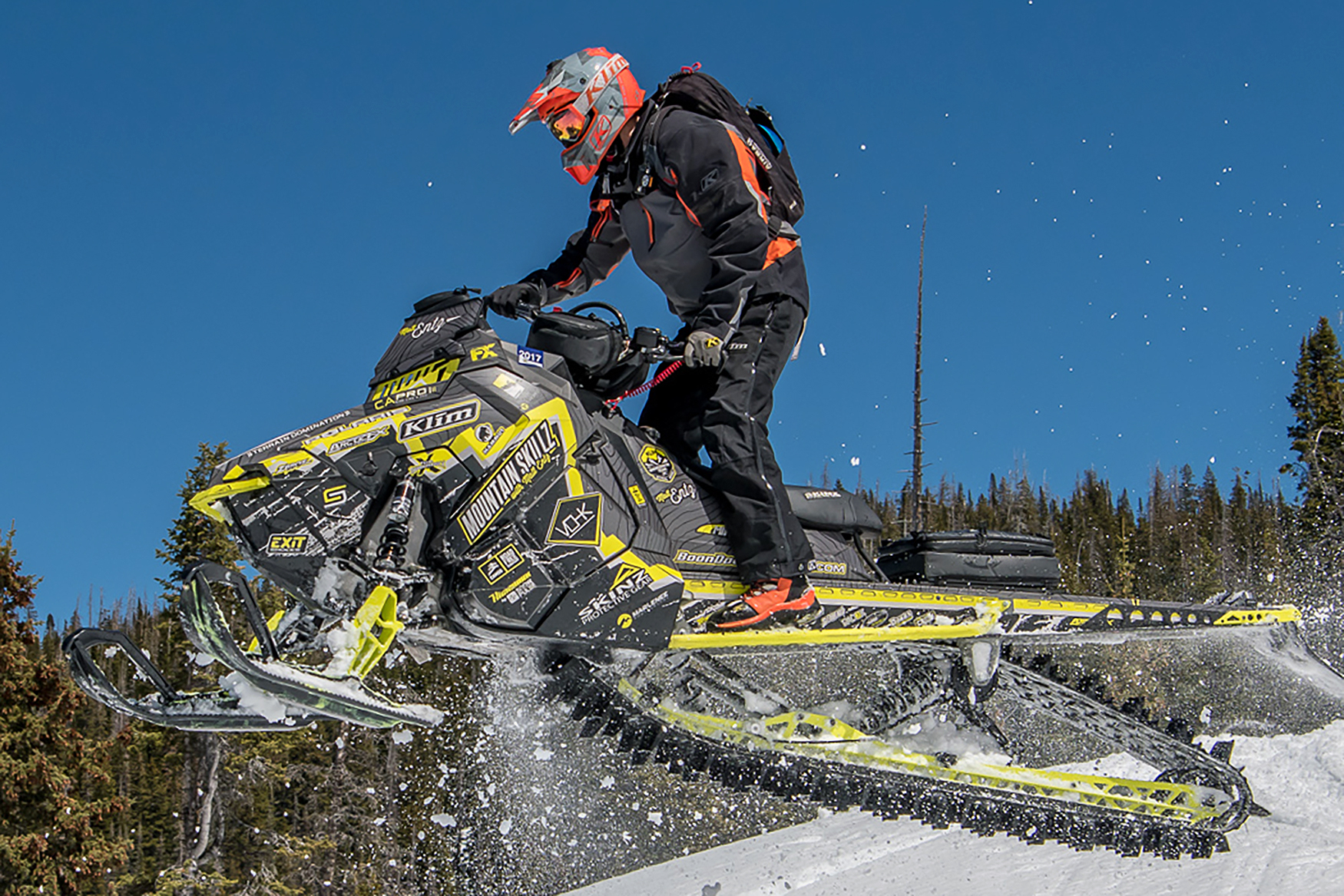 A Polaris Axys Mountain snowmobile with a lime squeeze, gray, and black Entz Frontier custom vinyl wrap.