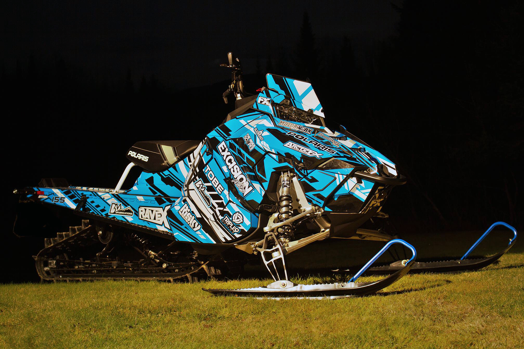 A Polaris Axys Mountain snowmobile with a blue, black, and white Evasion custom vinyl wrap.
