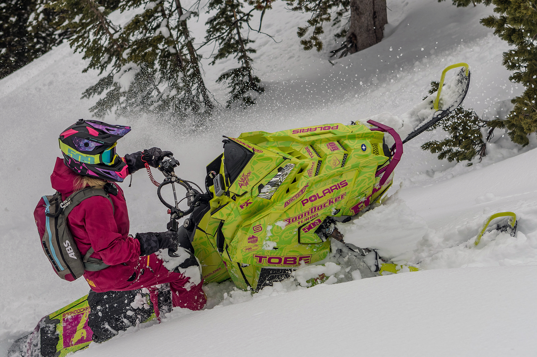 A Polaris Axys Mountain snowmobile with a lime squeeze and pink Onasch Fueled custom vinyl wrap.