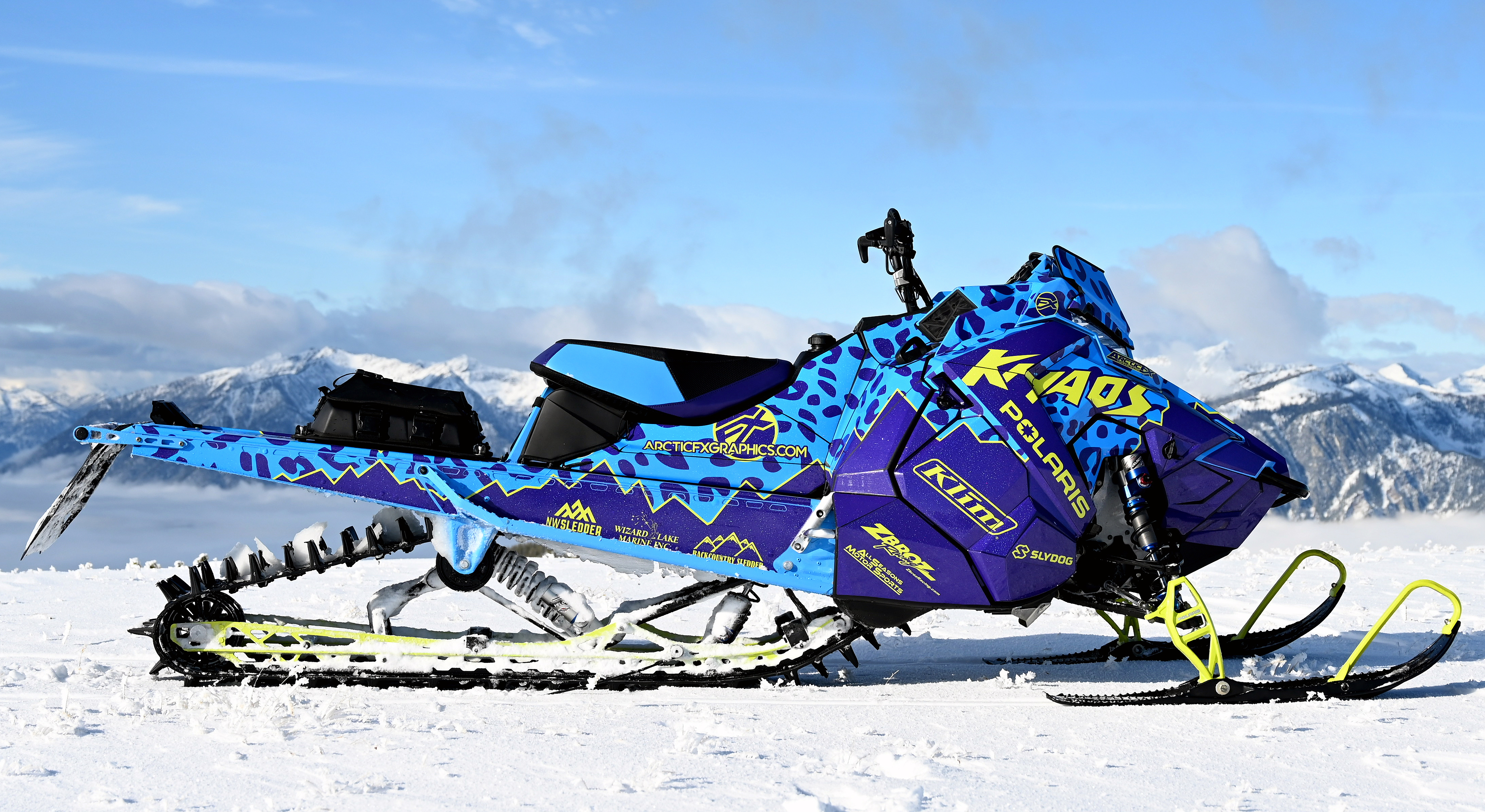 A Polaris Axys Mountain snowmobile with a lime squeeze, purple, blue, and black Hockley Cheetah Custom custom vinyl wrap.