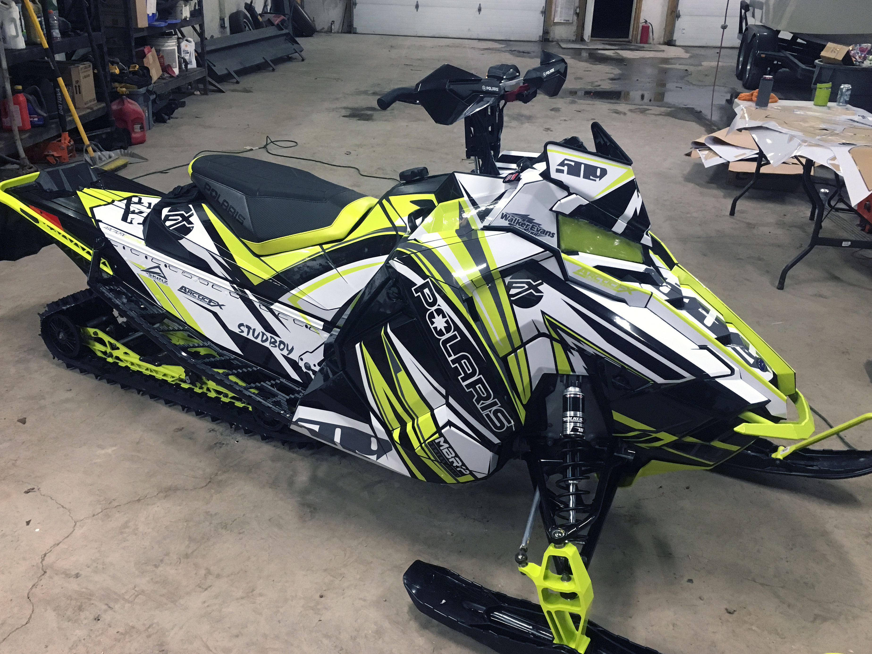 A Polaris Axys Mountain snowmobile with a white, black, and lime squeeze Kesterke Adrenaline custom vinyl wrap.