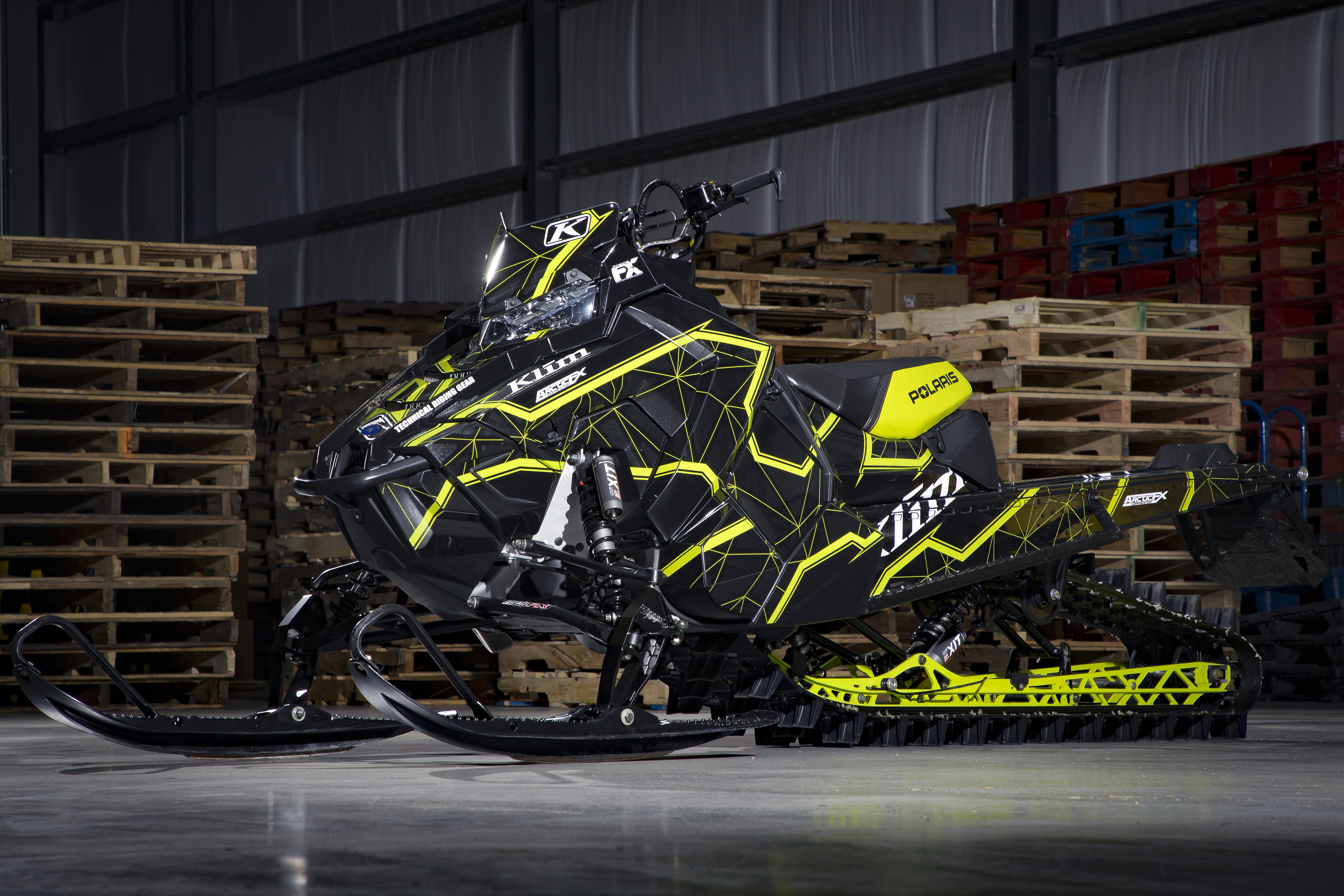 A Polaris Axys Mountain snowmobile with a black and lime squeeze Klim Demolish custom vinyl wrap.
