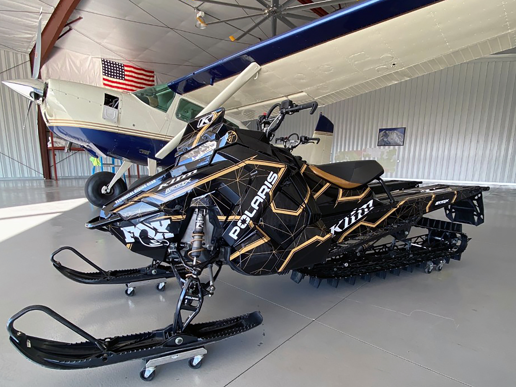 A Polaris Axys Mountain snowmobile with a black, tan, and white Klim Demolish custom vinyl wrap.